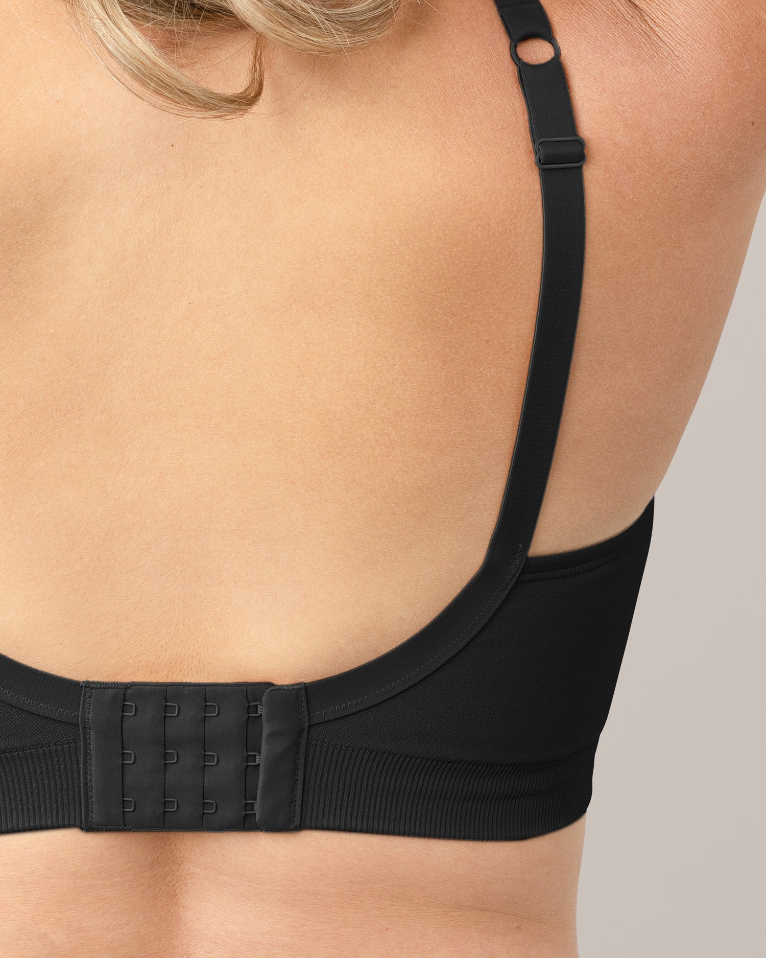 Close up of fabric, strap and hook & eye clasp detail on the Everly Wireless Contour Bra in Black, on woman.
