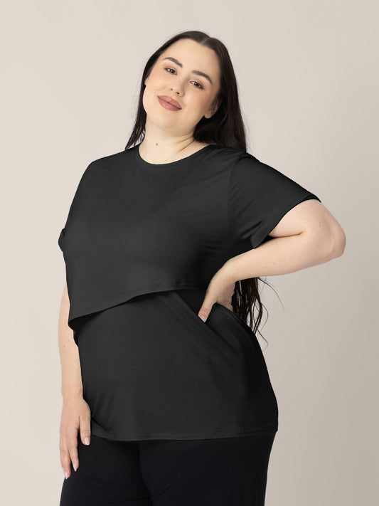 Three-quarters view of a model wearing the Everyday Asymmetrical Nursing T-shirt in Black @model_info:Rachel is wearing an X-Large.