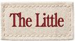 A rectangular cream-colored woven label or patch with the words 'The Little' embroidered in red serif lettering across the center.