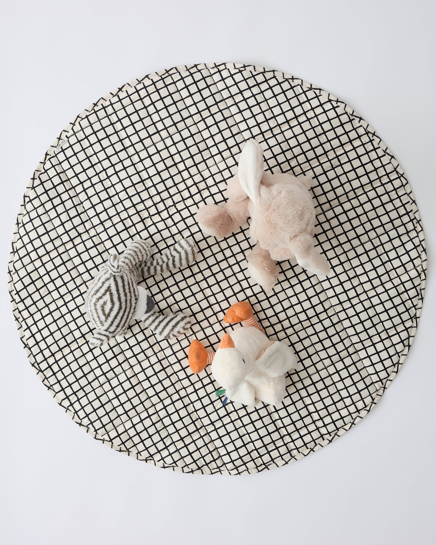 Inside/Outside Play Mat in Black Grid with three animal lovey dolls sitting ontop, on a beige background.