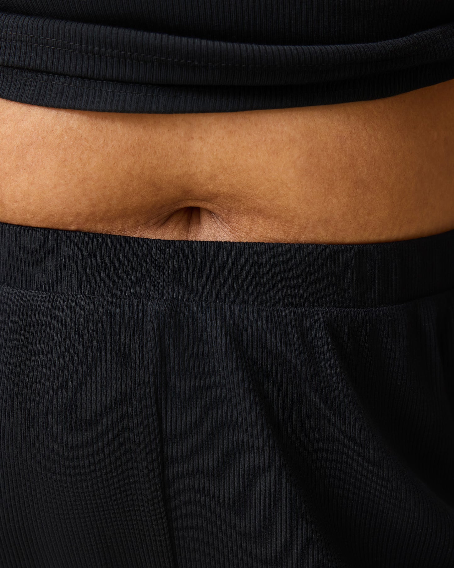 Close up on waist of model wearing Ribbed Modal Notched Nursing T-shirt in Black