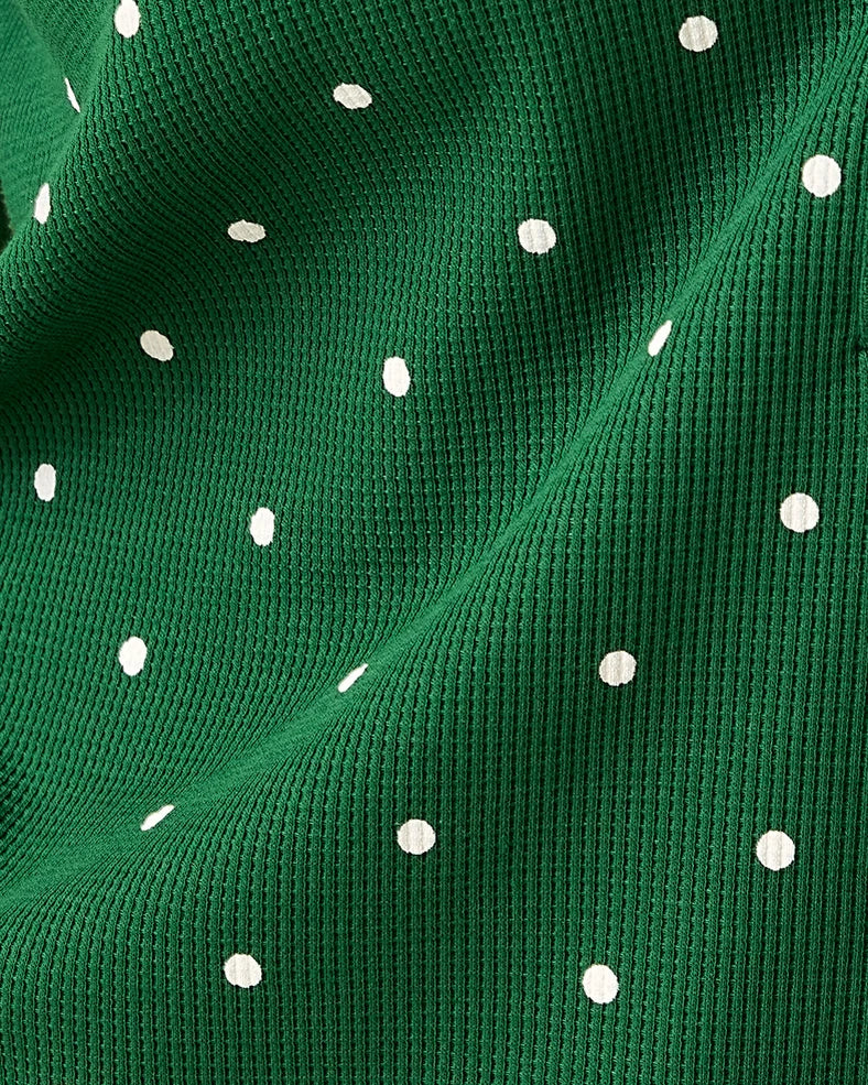 Close up on pattern and fabric of Waffle Maternity & Nursing Lounge Set in Green Dot on a beige background.