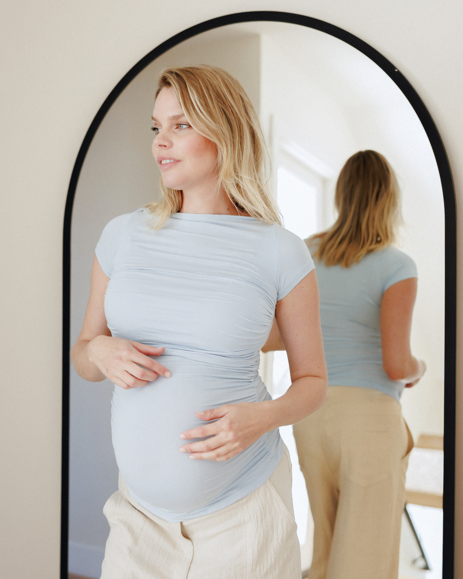 Front view of model standing in front of the mirror while wearing Kiera Boat Neck Maternity & Nursing Top in French Blue @model_info:Anna is wearing a Small.
