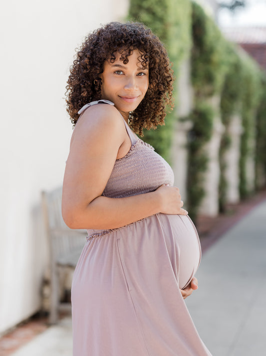 Pregnant model wearing the Sienna Smocked Maternity & Nursing Dress in lilac stone@model_info:Alysha is 5'6" and wearing a Large.