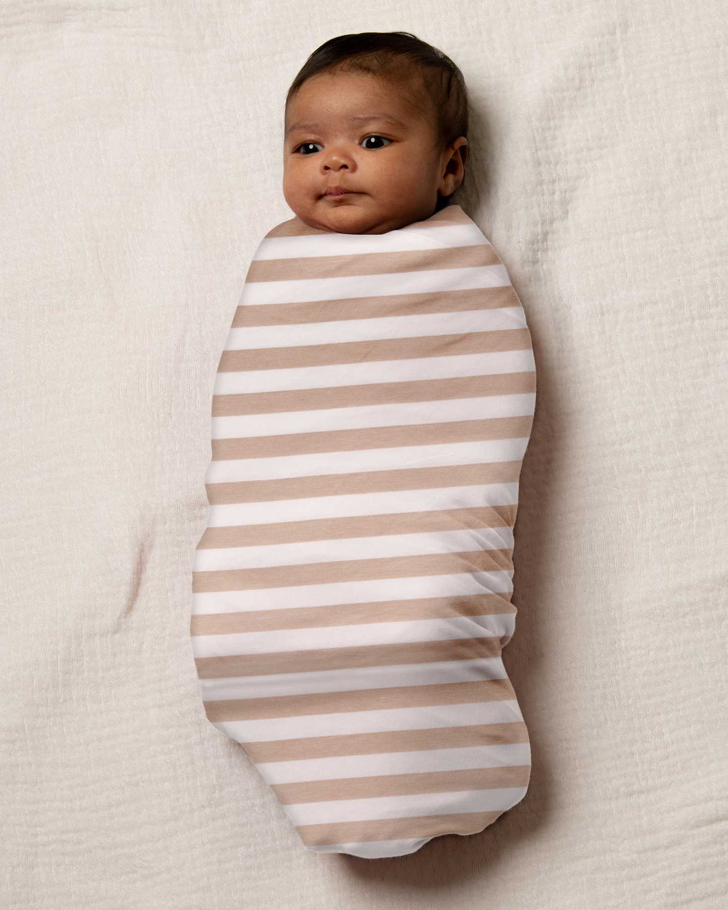 Baby swaddled in Bamboo Swaddle Blanket in Fawn Stripe neutral background@model_info:Luna is 6 weeks old.