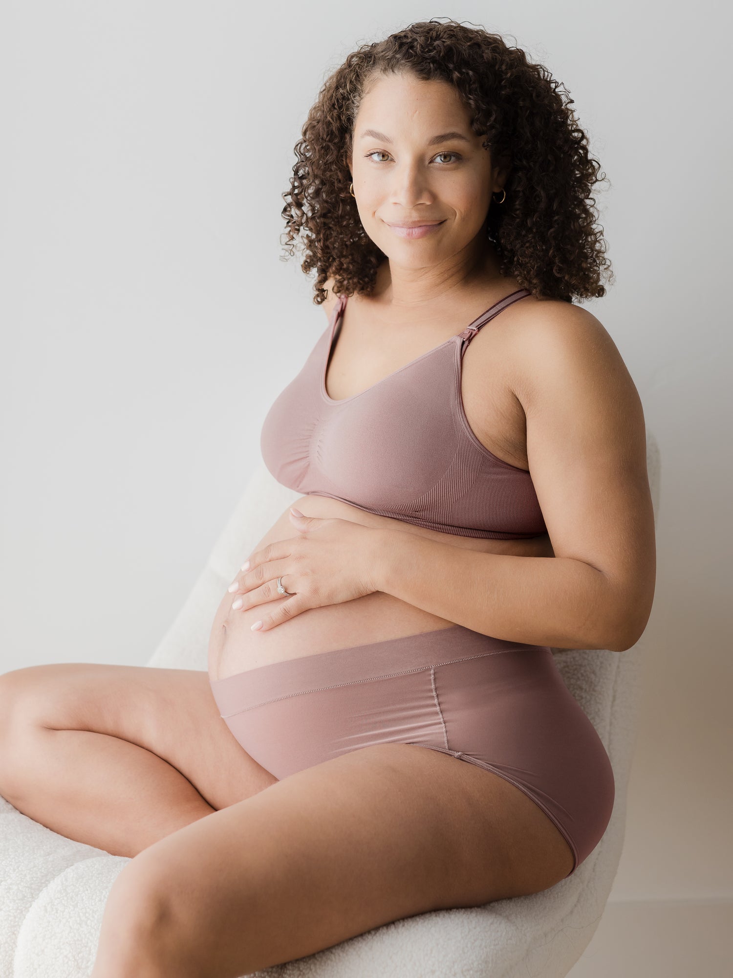 Pregnant model sitting in chair wearing the Twilight Grow with Me™ Maternity & Postpartum Boyshort in Twilight with matching bra