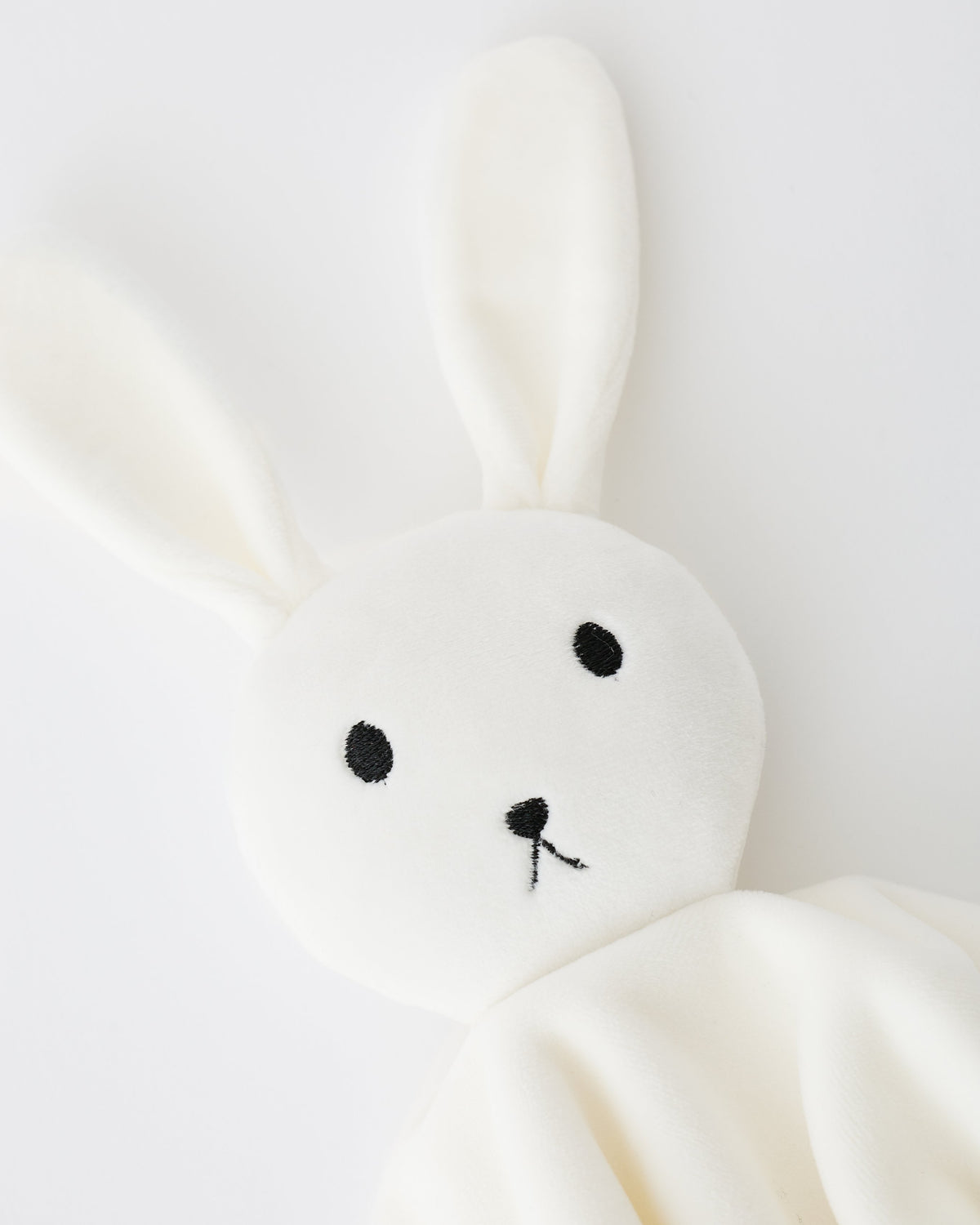 Close up of face detail of Ivory Bunny Cuddle Buddy Lovey on an off white background.