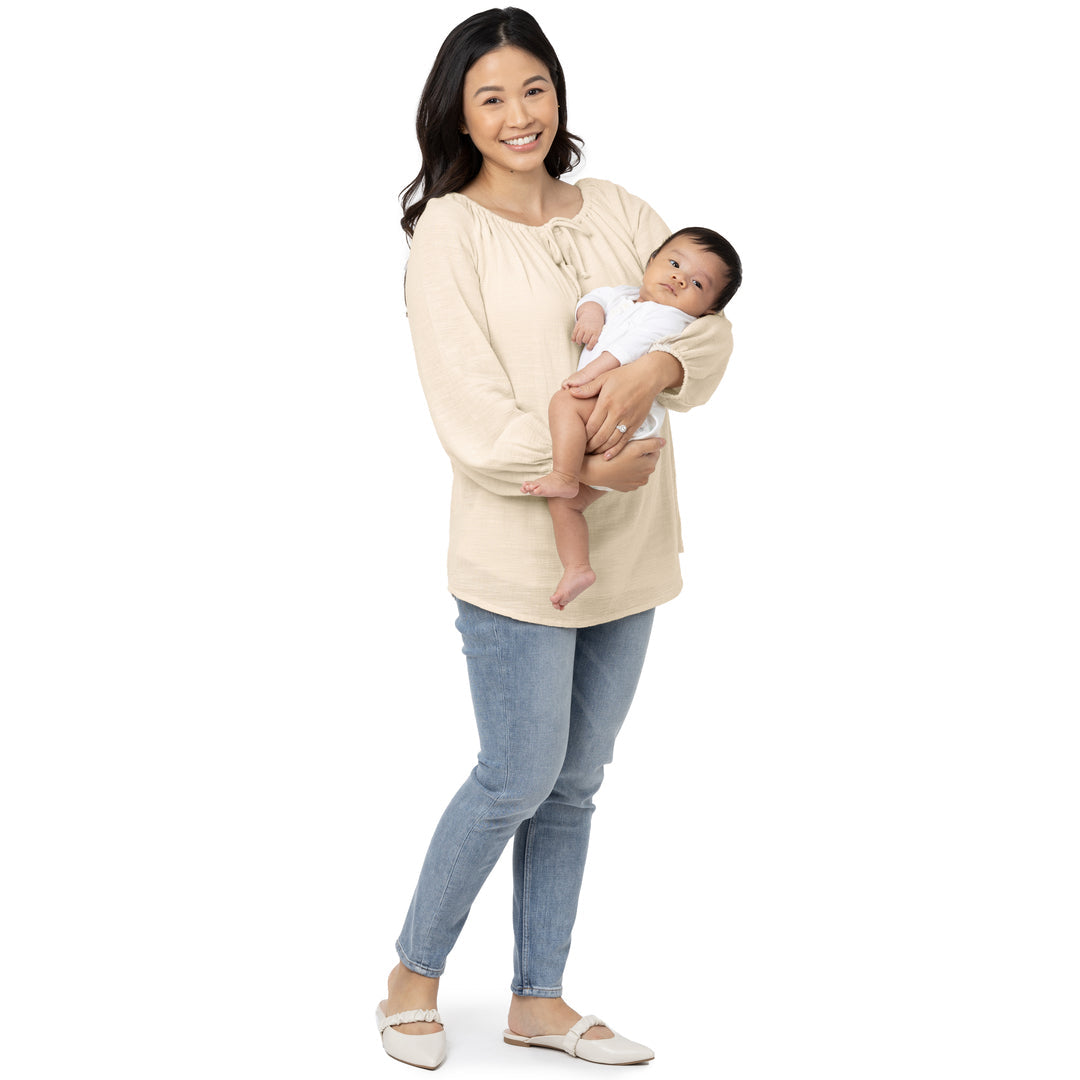 Model standing with her baby while wearing the Long Sleeve Nursing Blouse@model_info:Jay is wearing a Small.