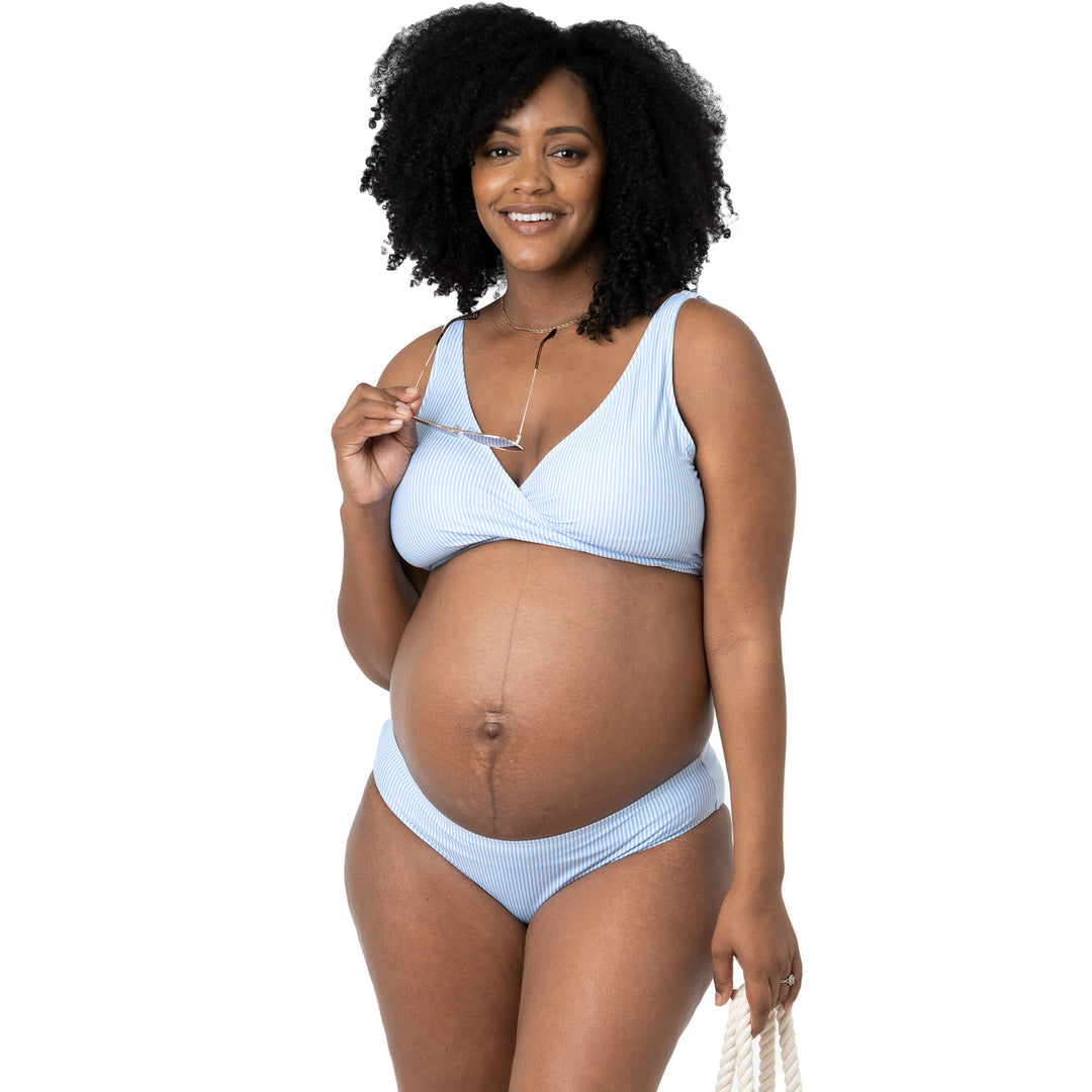 Pregnant model wearing the Low Rise Maternity & Postpartum Bikini Bottom in Coastal Stripe with sunglasses.