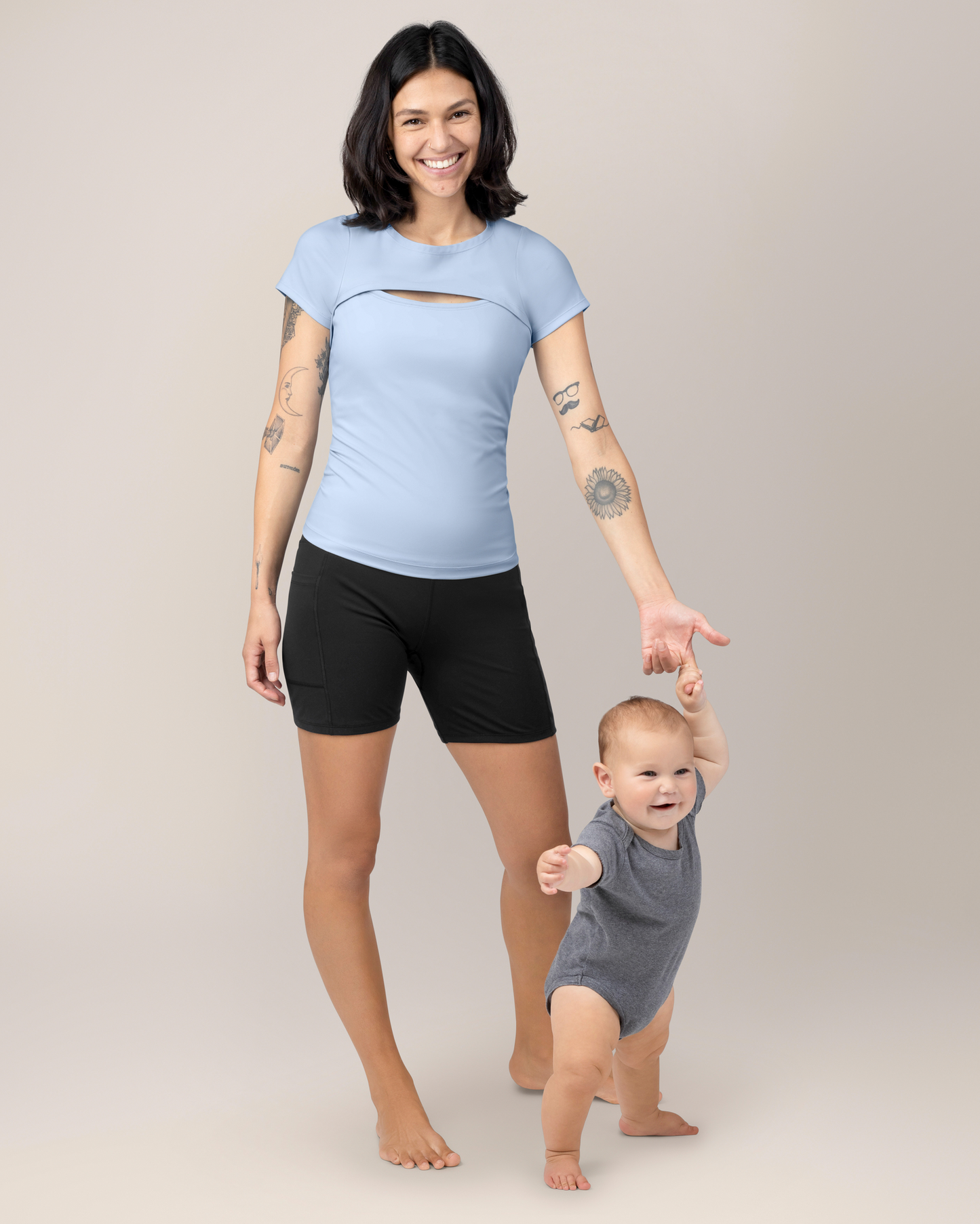 Front view of model with baby wearing the Luna Active Cut Out Nursing Top in French Blue @model_info:Megan is wearing a Small.