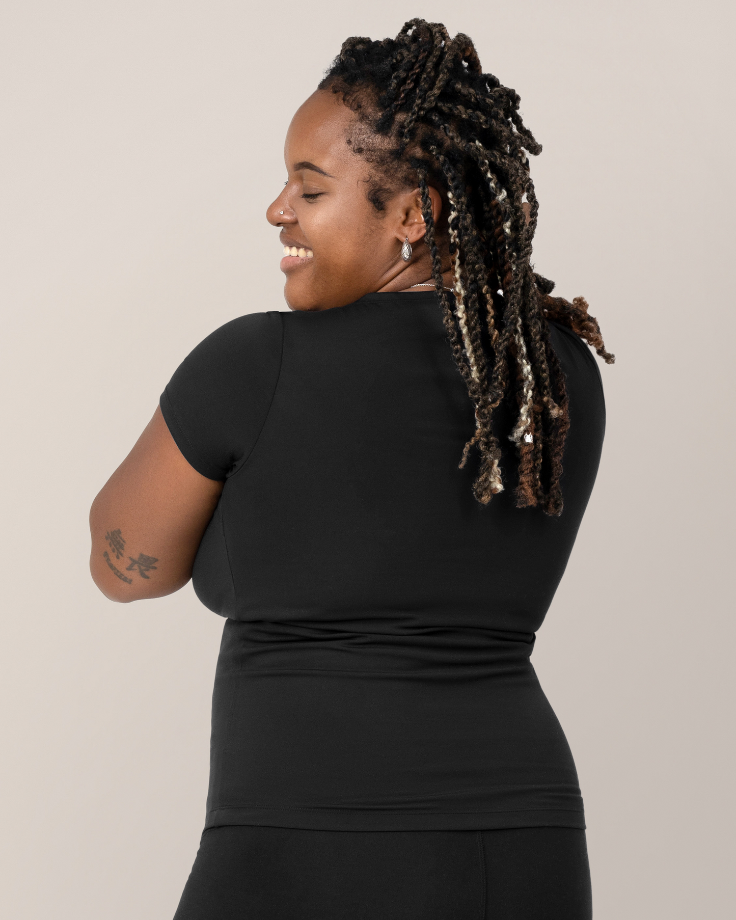 Back view of model wearing the Luna Active Cut Out Nursing Top in Black