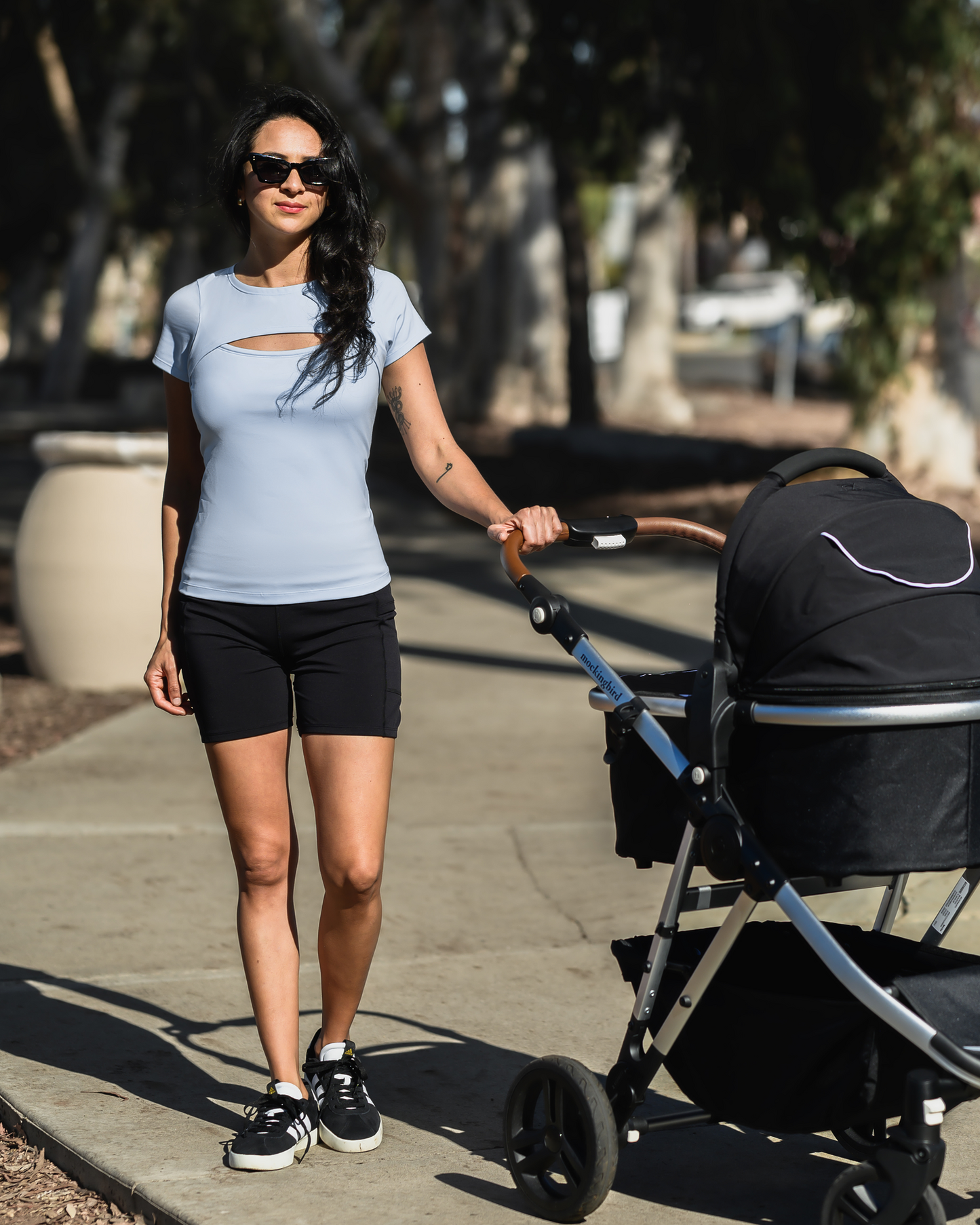 Model pushing baby stroller wearing the Luna Active Cut Out Nursing Top in French Blue @model_info:Ezmie is wearing a Small.