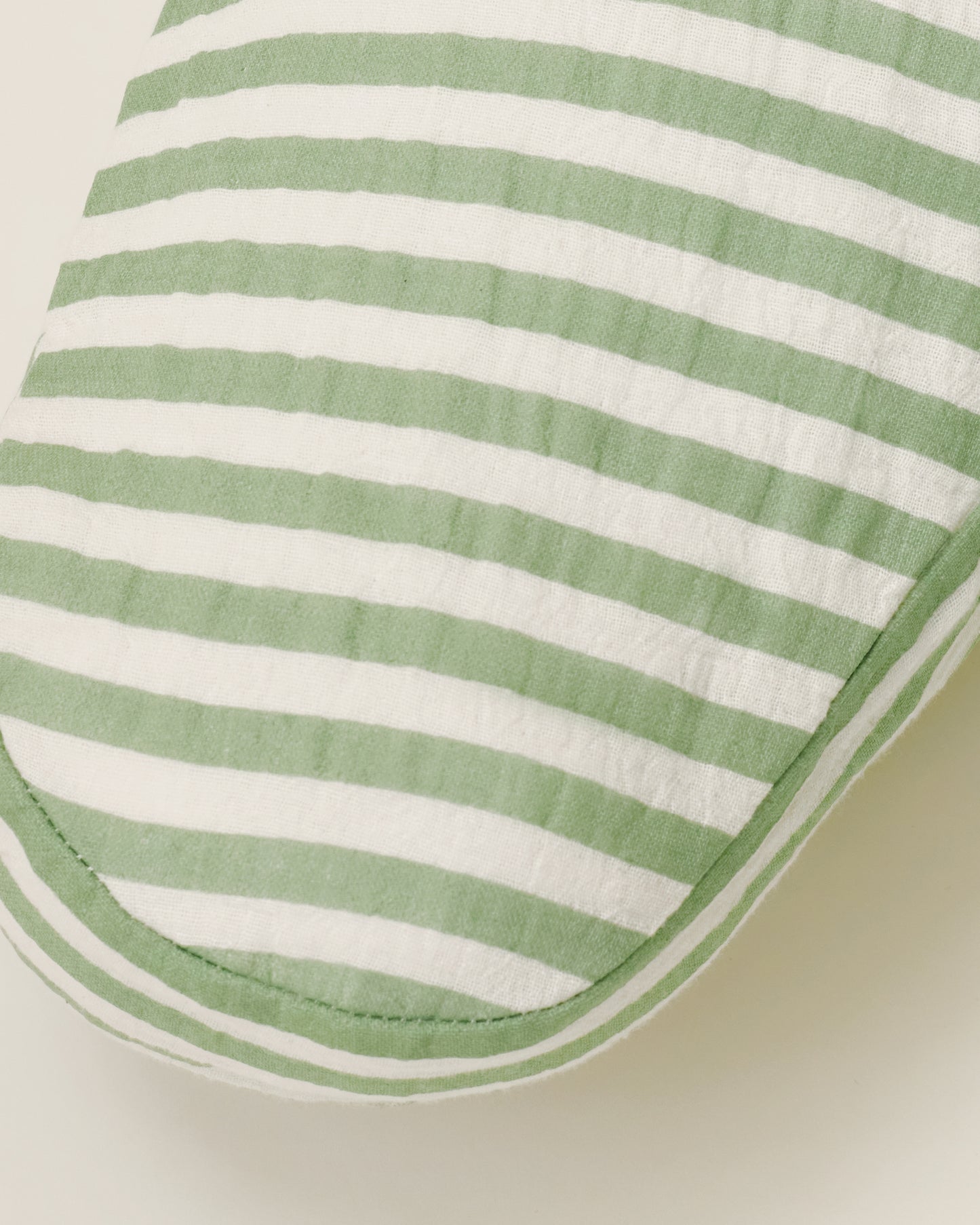 Close up of the Organic Muslin Nursing Pillow Cover in the Sage Stripe print