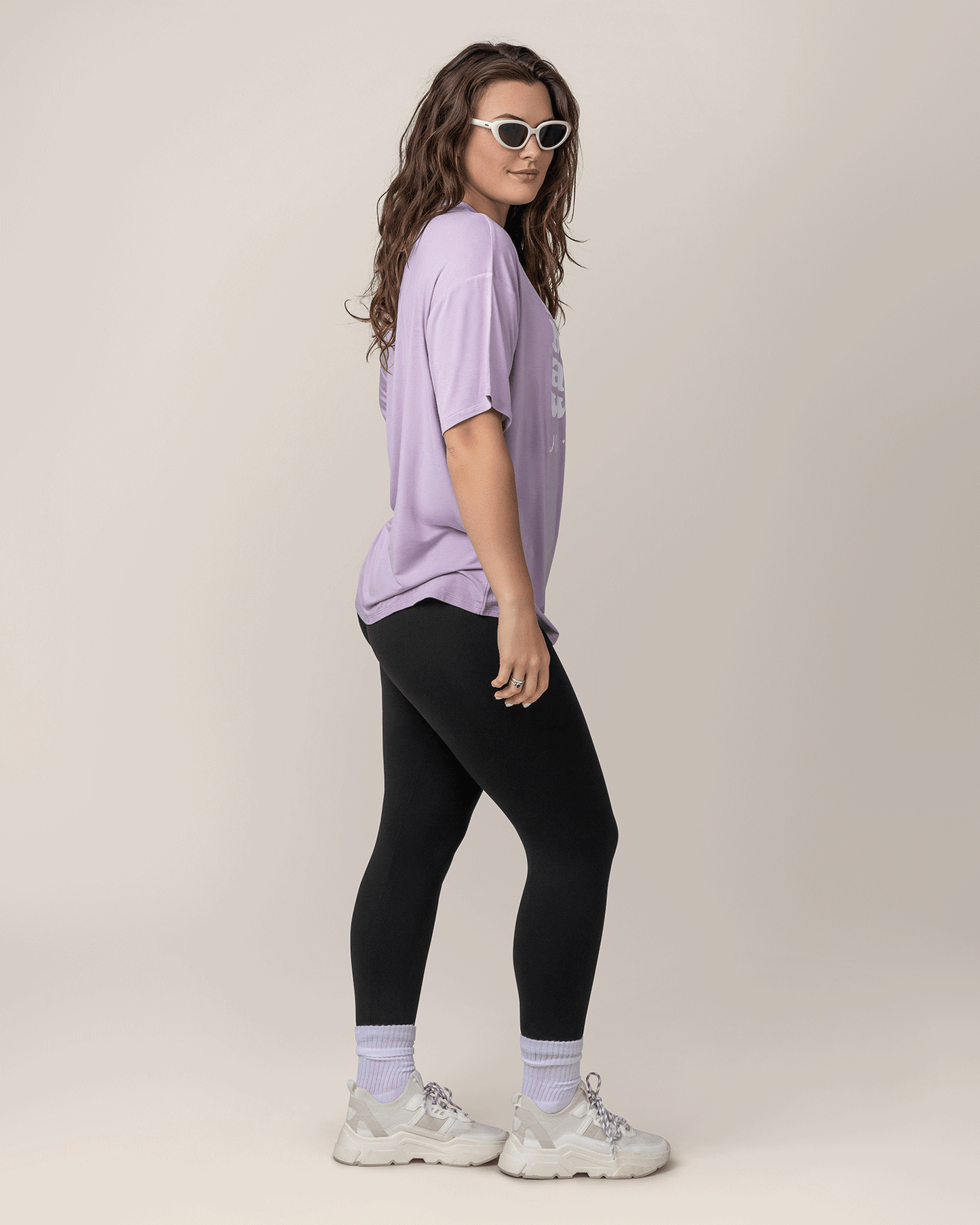 Side view of model wearing Oversized Graphic Tee in For All I'm Worth