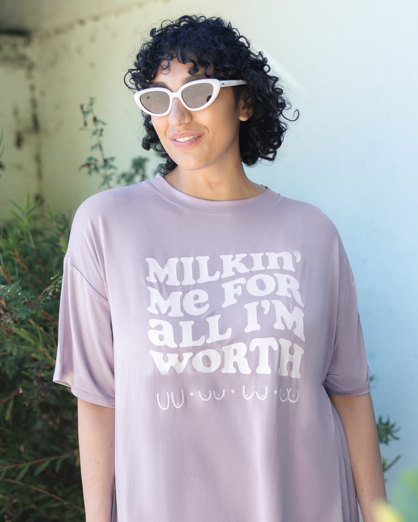 Close up of model wearing the Oversized Graphic Tee in For All I'm Worth, focused on "Milkin' Me For All I'm Worth" design