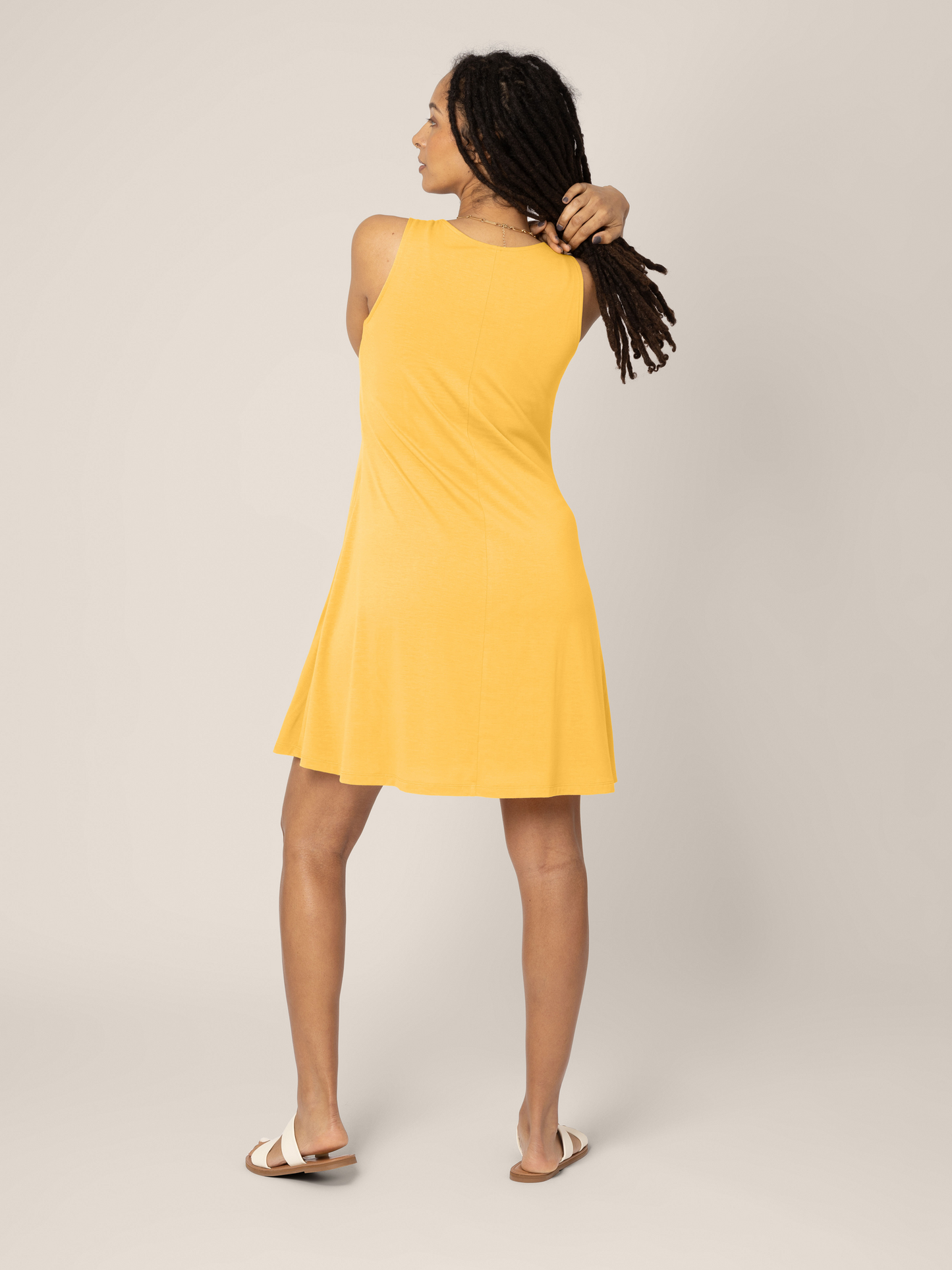 Back view of model wearing Penelope Dress in Citrus Yellow. 