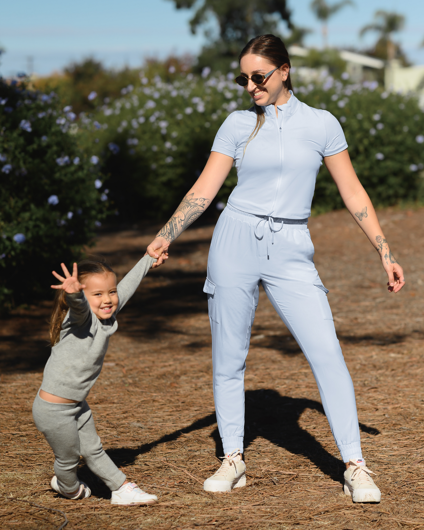 Model playing with child while wearing the Presley Active Zip Front Nursing Top in Light Blue with matching Remy Maternity & Postpartum Cargo Jogger