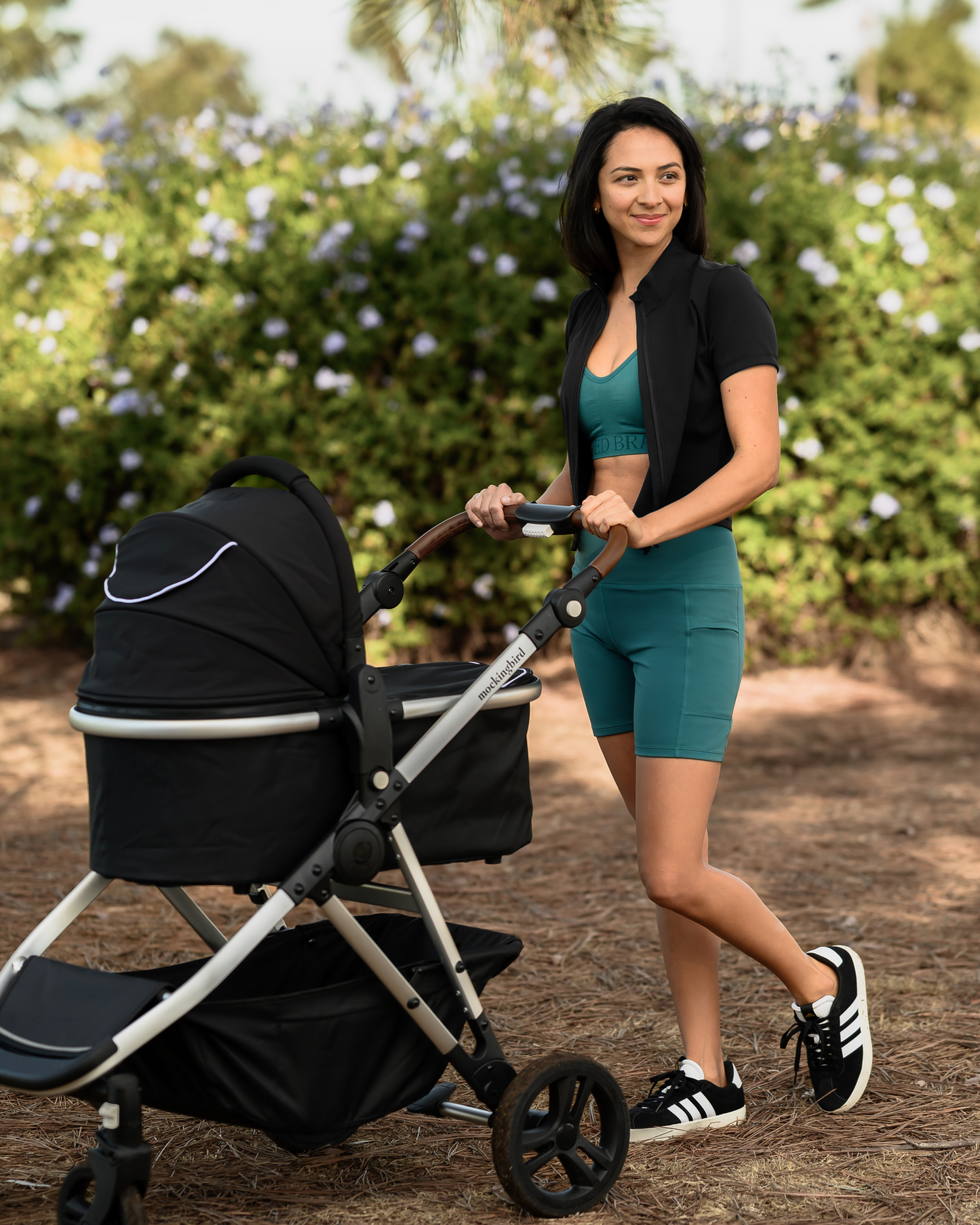 Model pushing baby stroller wearing the Presley Active Zip Front Nursing Top in Black