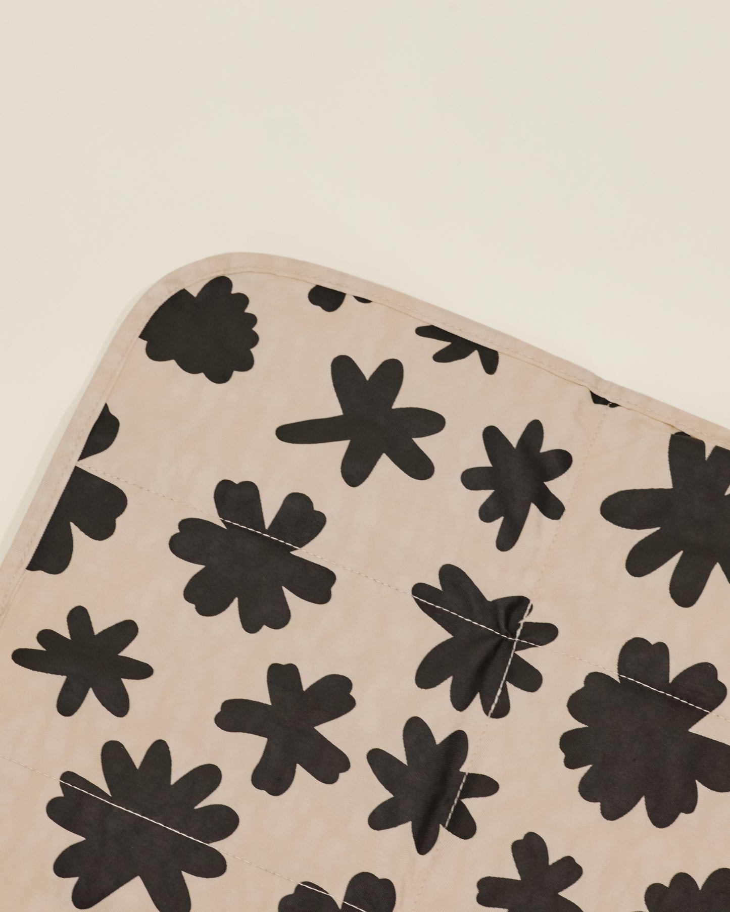 Close up of Quick Change Kit Bag in Cream Chamomiles print, showing the folded changing pad inside