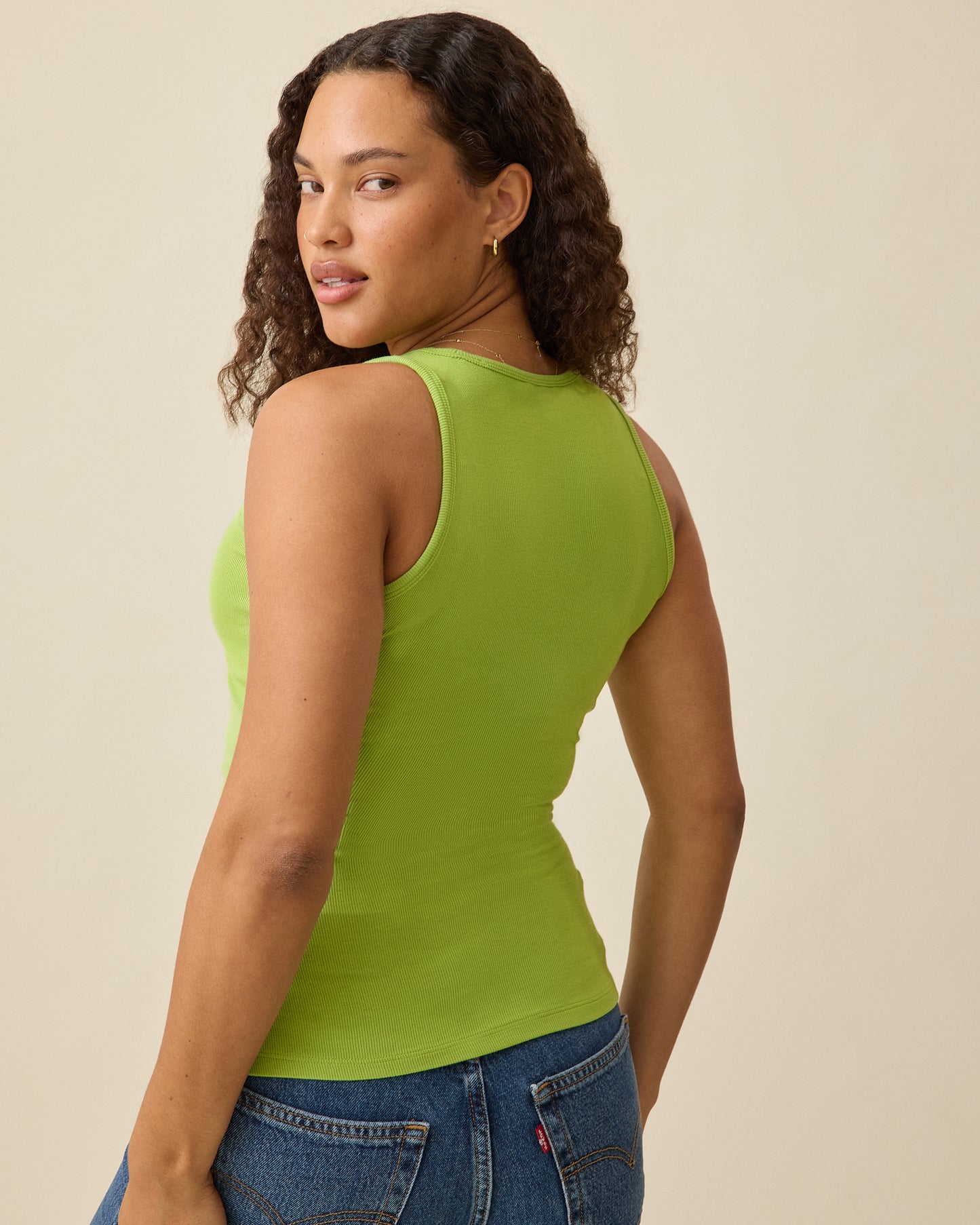 Model displaying back view of Ribbed Bamboo Scoop Neck Nursing Tank in Avocado on a beige background