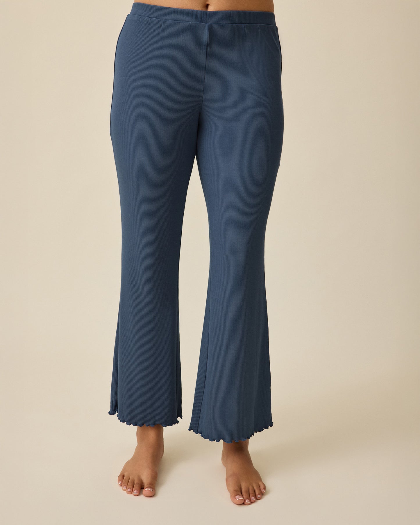 Close-up of model wearing Ribbed Modal Lounge Pant in Light Navy on a beige background.