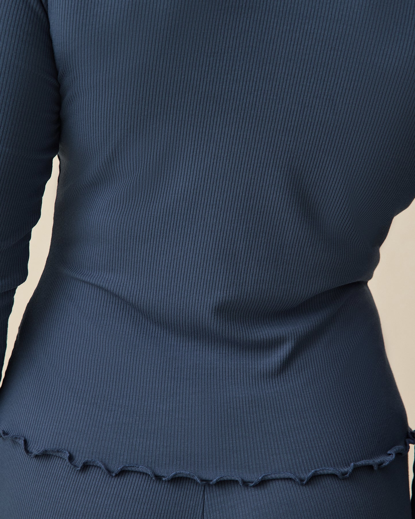Close up of back view of Ribbed Modal Cardigan and Lounge Pant in Light Navy on a beige background.