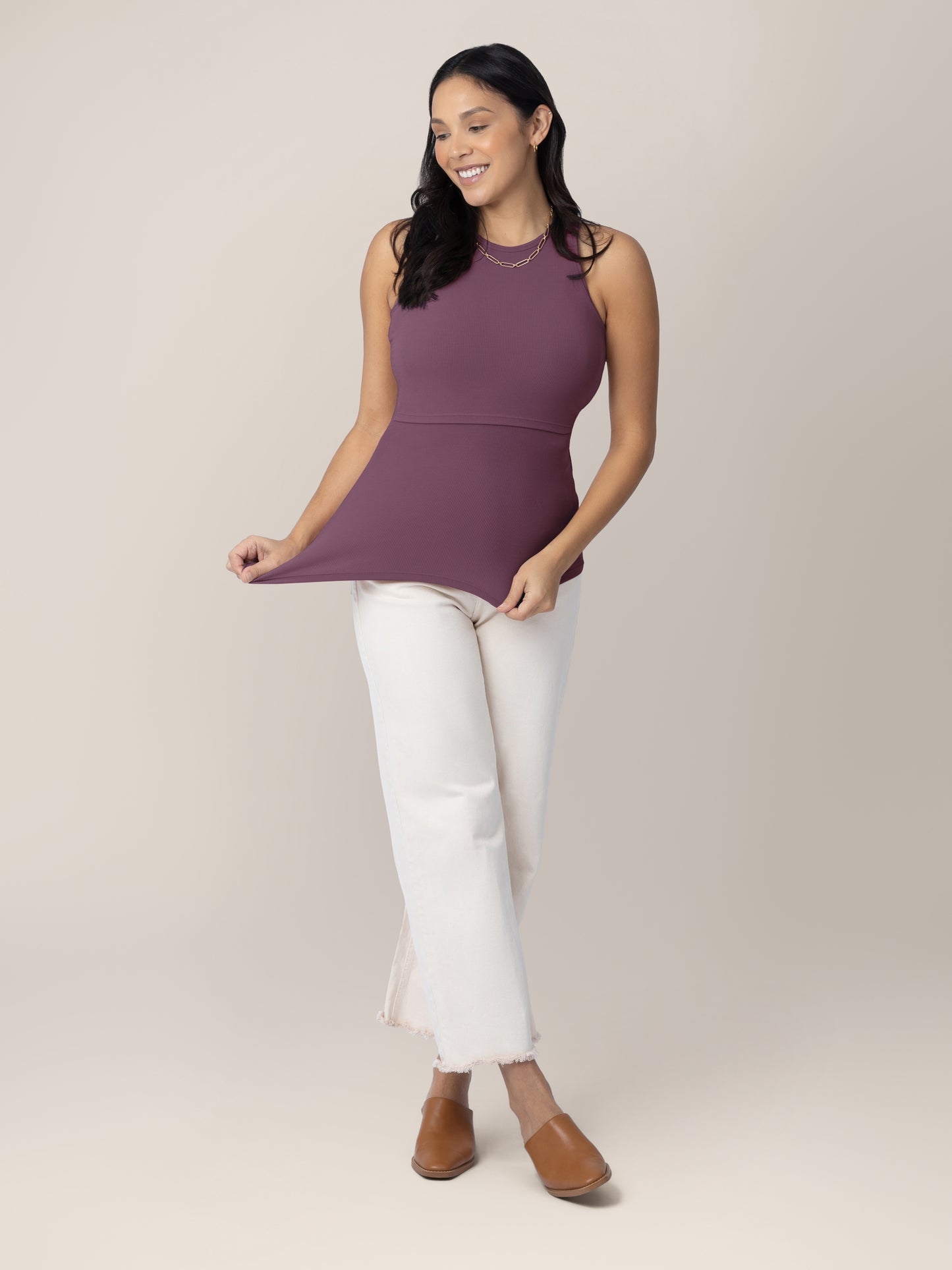 Full body front view of model wearing the Ribbed Bamboo Racerback Nursing Tank in burgundy plum, showing stretch, paired with white raw edge straight leg cropped jeans