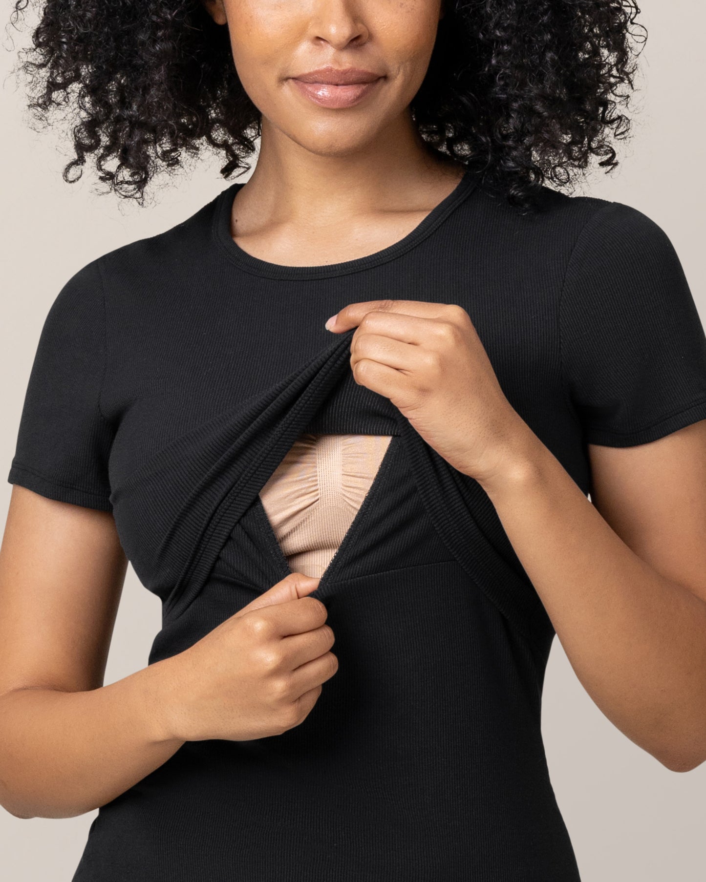 Model wearing Ribbed Bamboo Crew Neck Nursing T-shirt in Black lifting up top outer layer to show nursing access