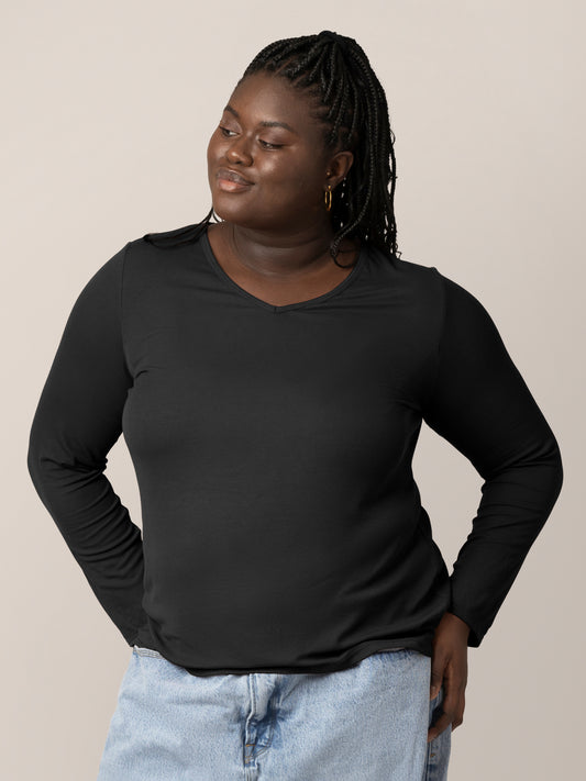 Front view of model wearing the Ribbed Bamboo Maternity & Nursing Long Sleeve T-shirt in Black, with hands on hips @model_info:Bintou is wearing an X-Large.