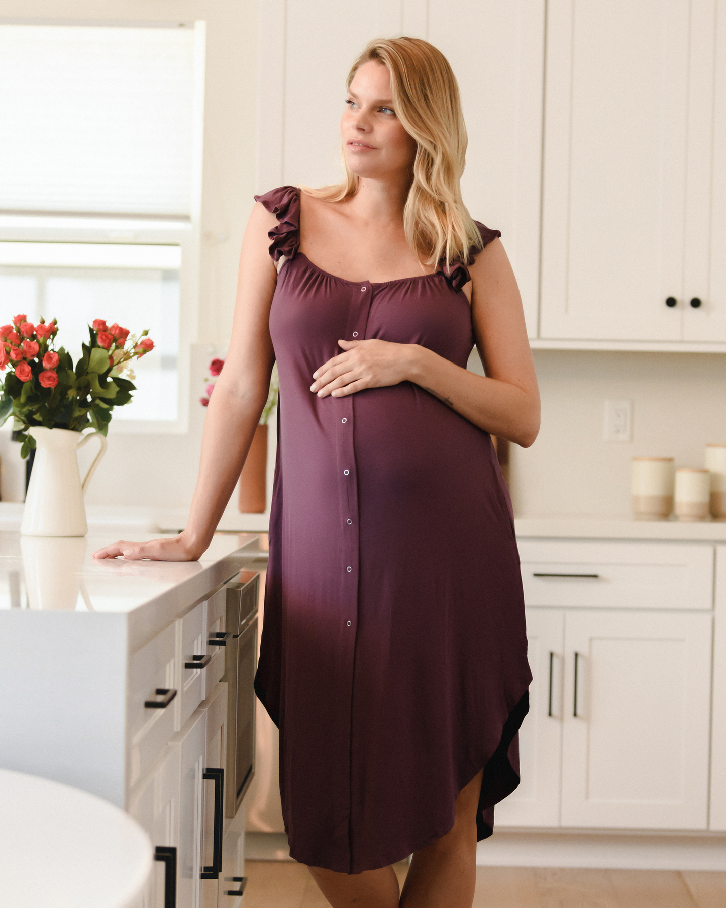 Model standing at countertop wearing the. Ruffle Strap Labor & Delivery Gown in Burgundy Plum @model_info:Anna is 5'10" and wearing an XS/S.