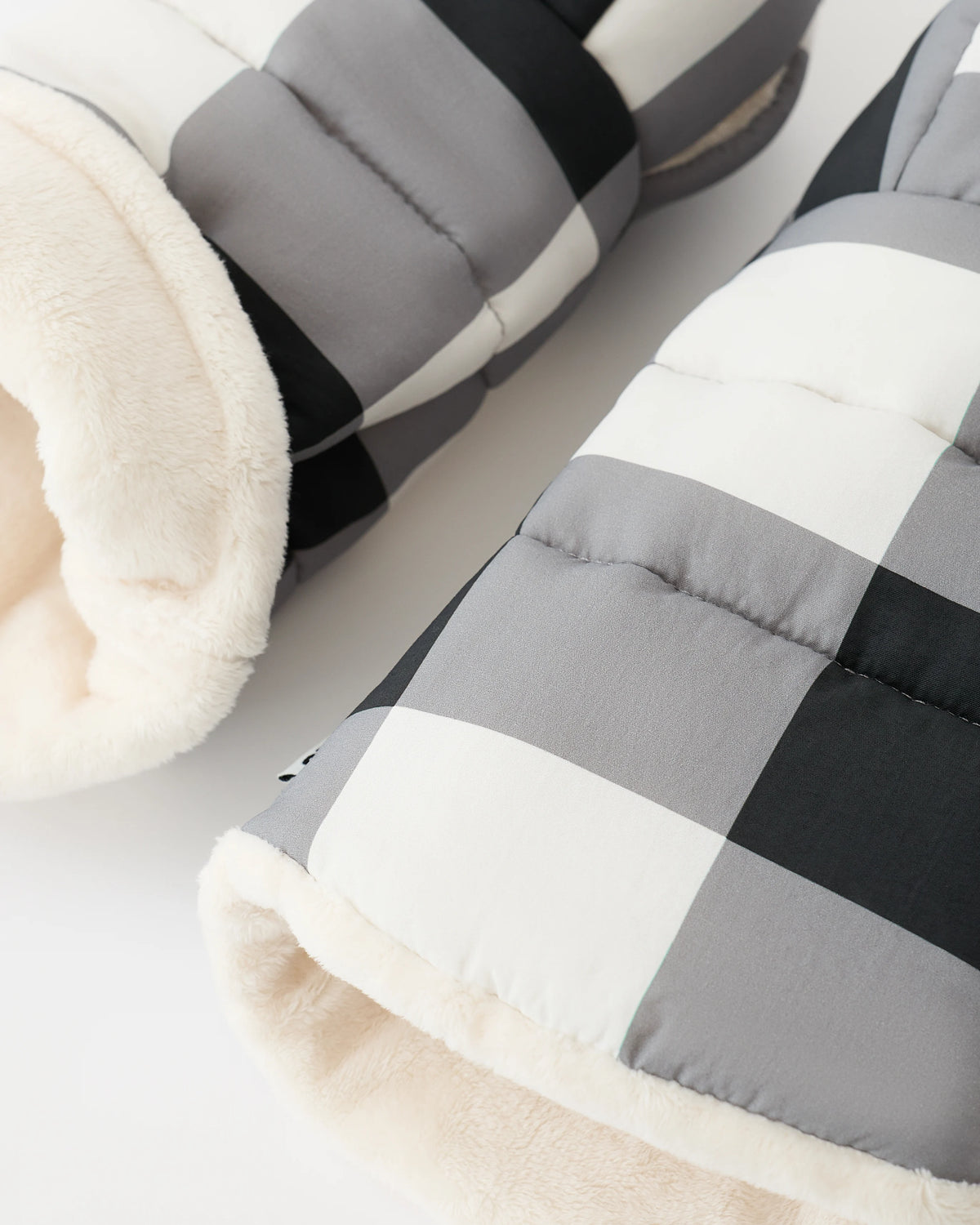 Close up of the fuzzy interior of the Cozy Stroller Mitts in Buffalo Plaid on an off white background.