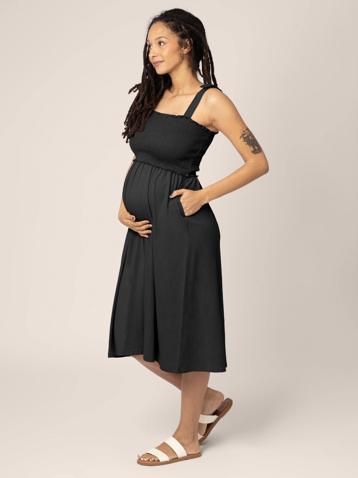 Pregnant model wearing the Sienna Smocked Maternity & Nursing Dress in black