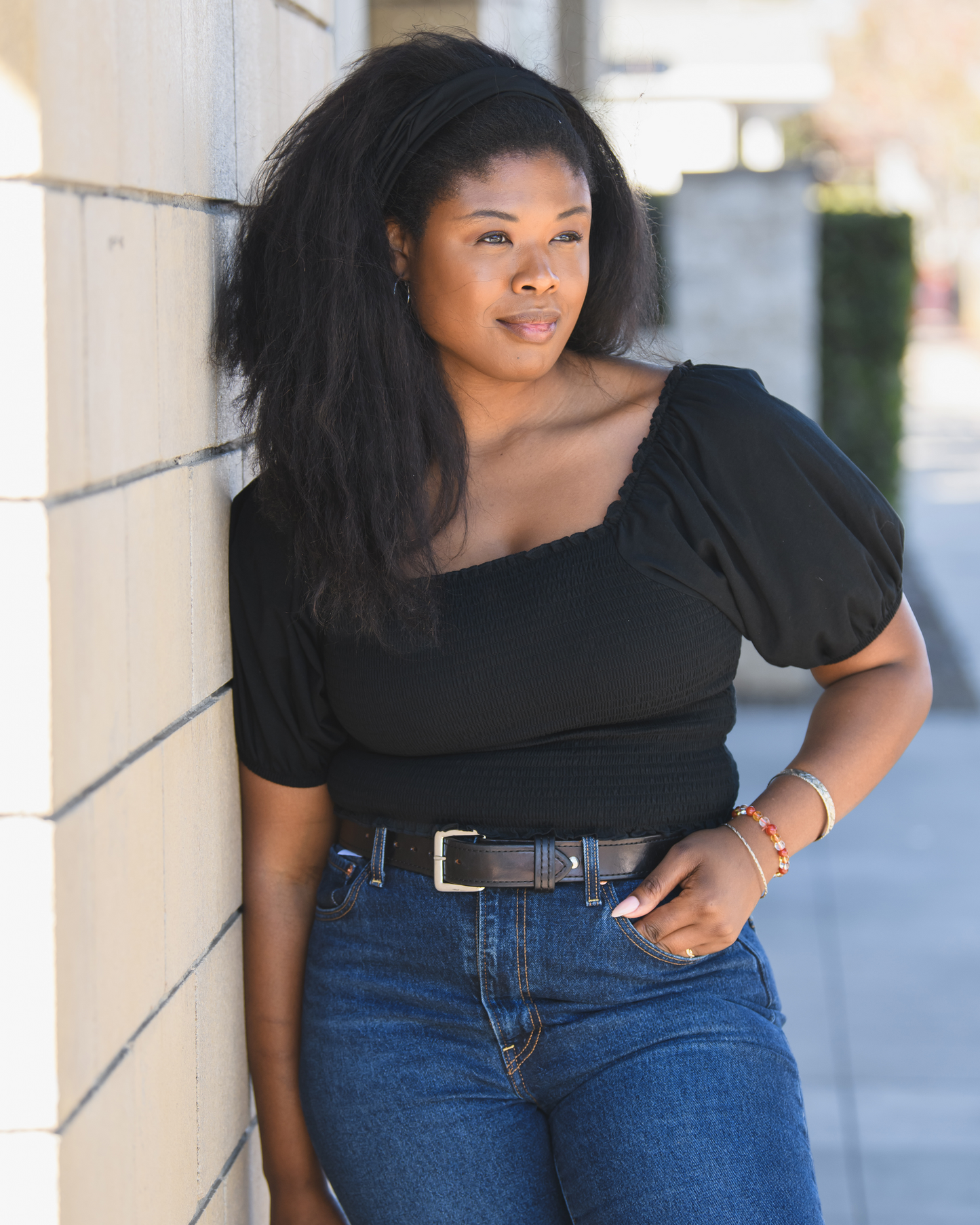 Model outside wearing the Sophia Smocked Cropped Nursing Top in Black @model_info:Joy is wearing a Large.