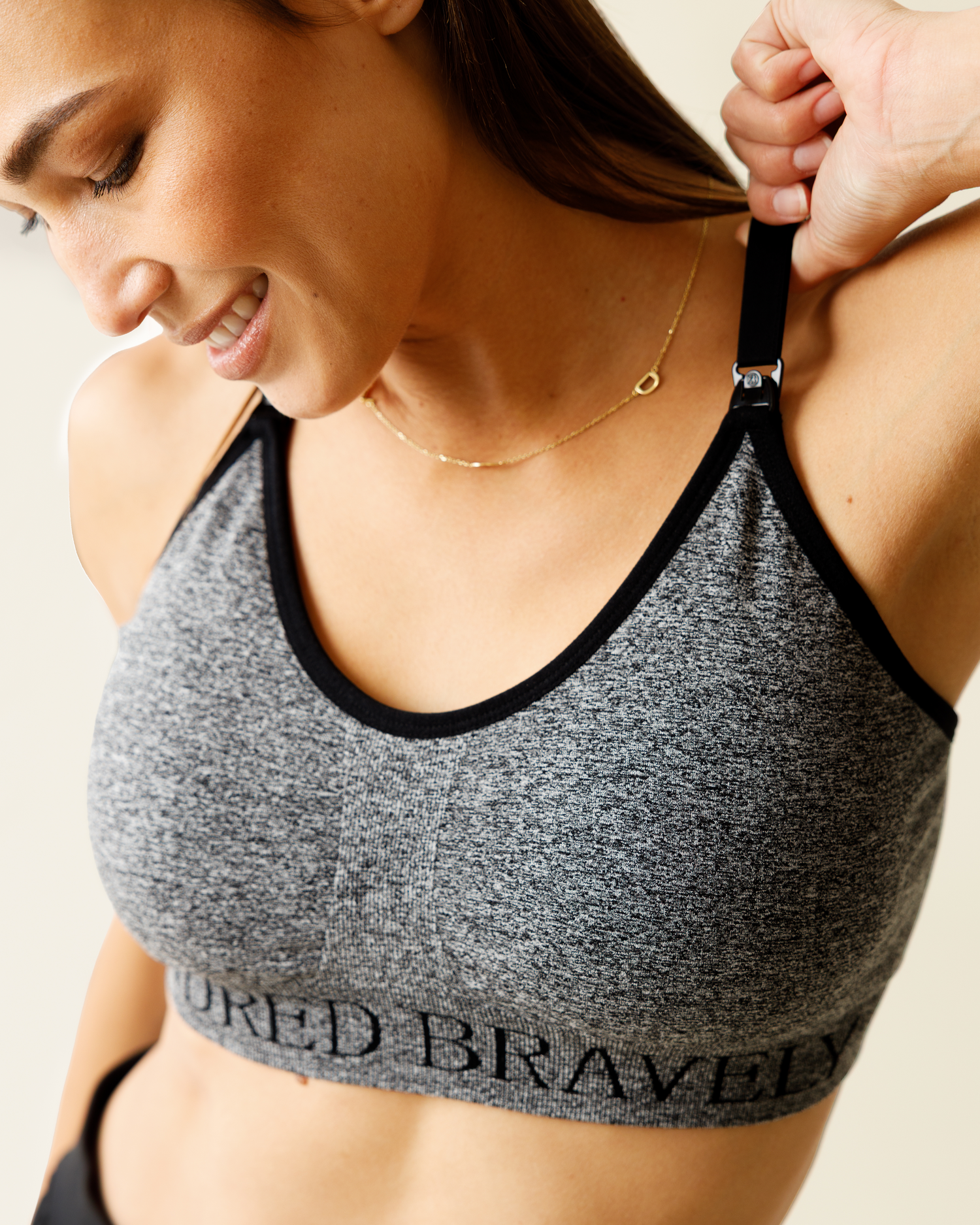 Close up of woman wearing the Sublime® Nursing Sports Bra in Grey Heather on beige background
