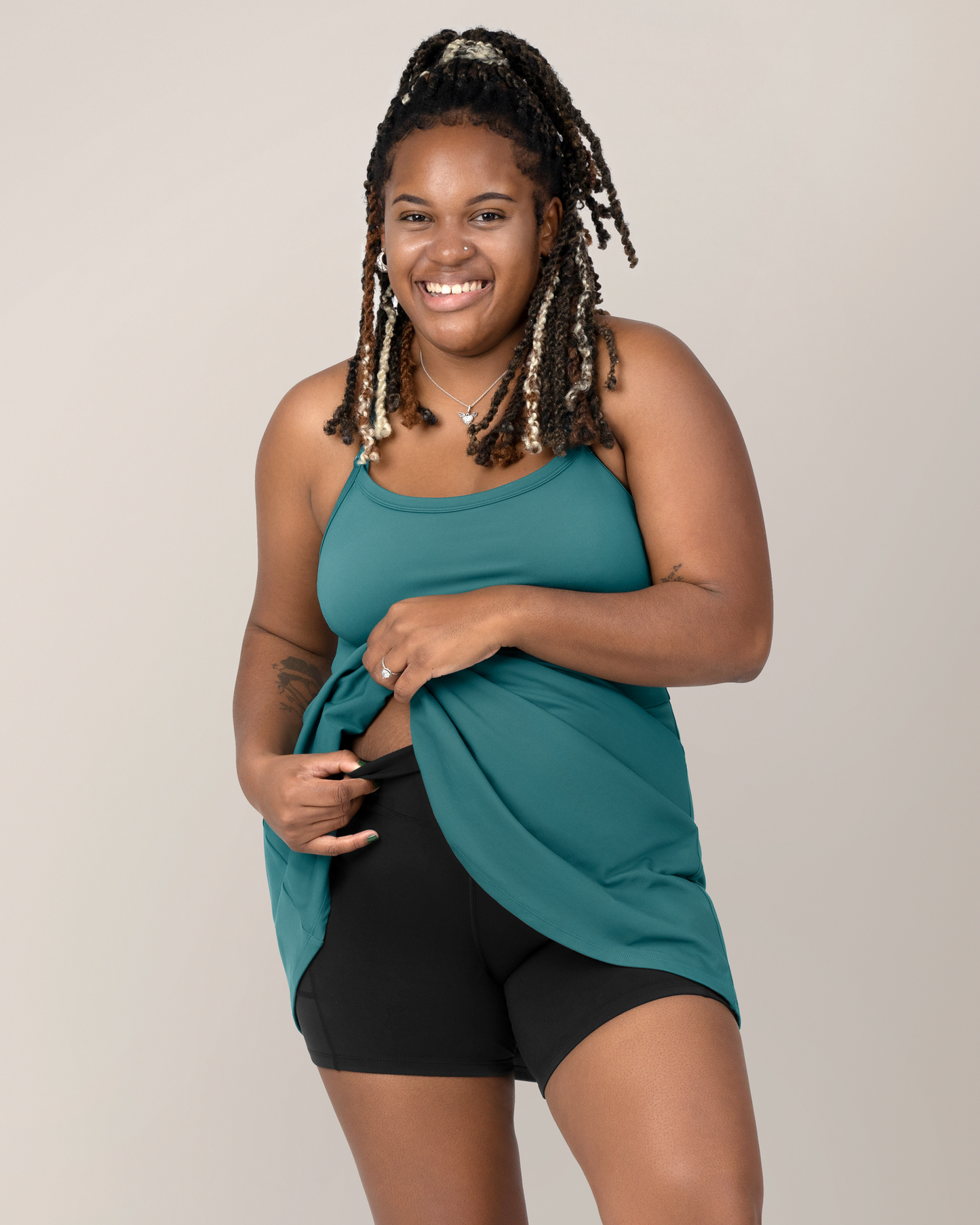 Detail view of Model wearing the Stevie Active Postpartum Bike Short in Black with the Steview Active Racerback Nursing Dress in Teal