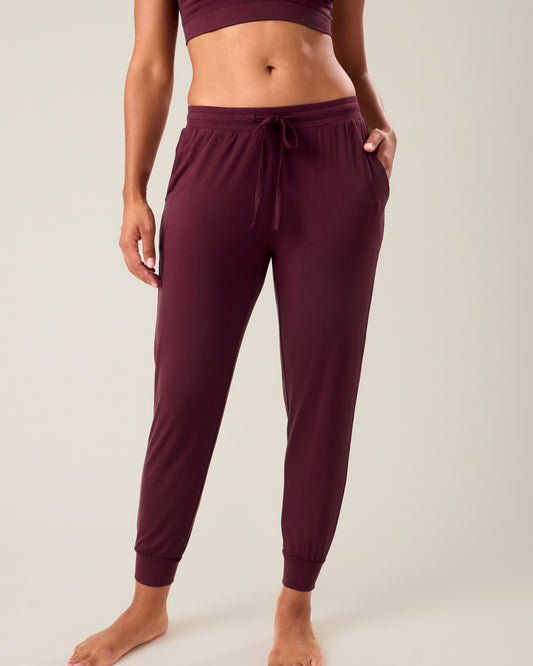 Woman wearing the Everyday Lounge Jogger in deep burgundy, paired with matching bra@model_info:Nemesis is 5'9" and wearing a Small.