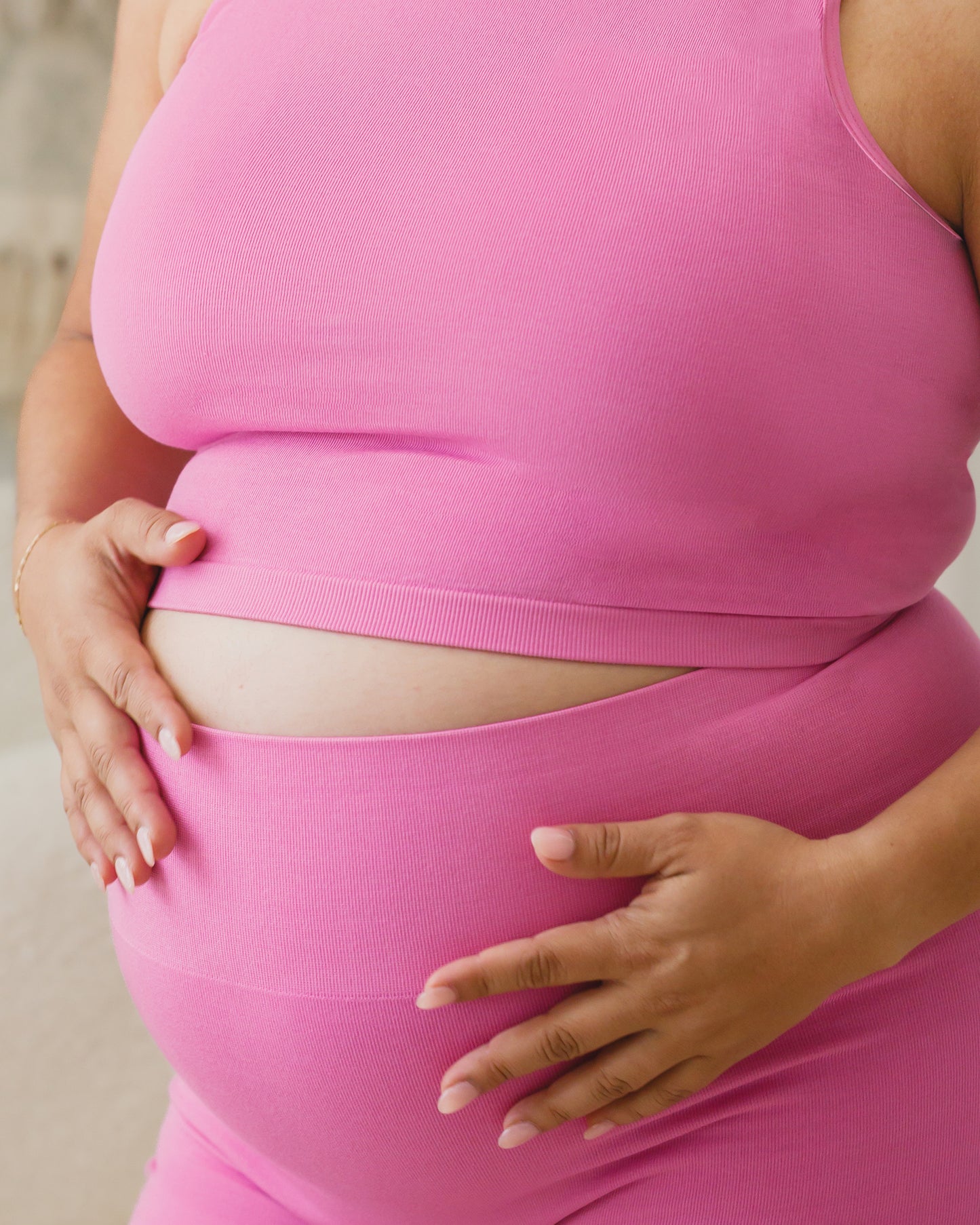 Cropped in view of pregnant model wearing the Sublime® Bamboo Maternity & Postpartum Bike Short in Soft Fuchsia, focusing on band and paired with matching Sublime® Bamboo Maternity & Nursing Longline Bra Top