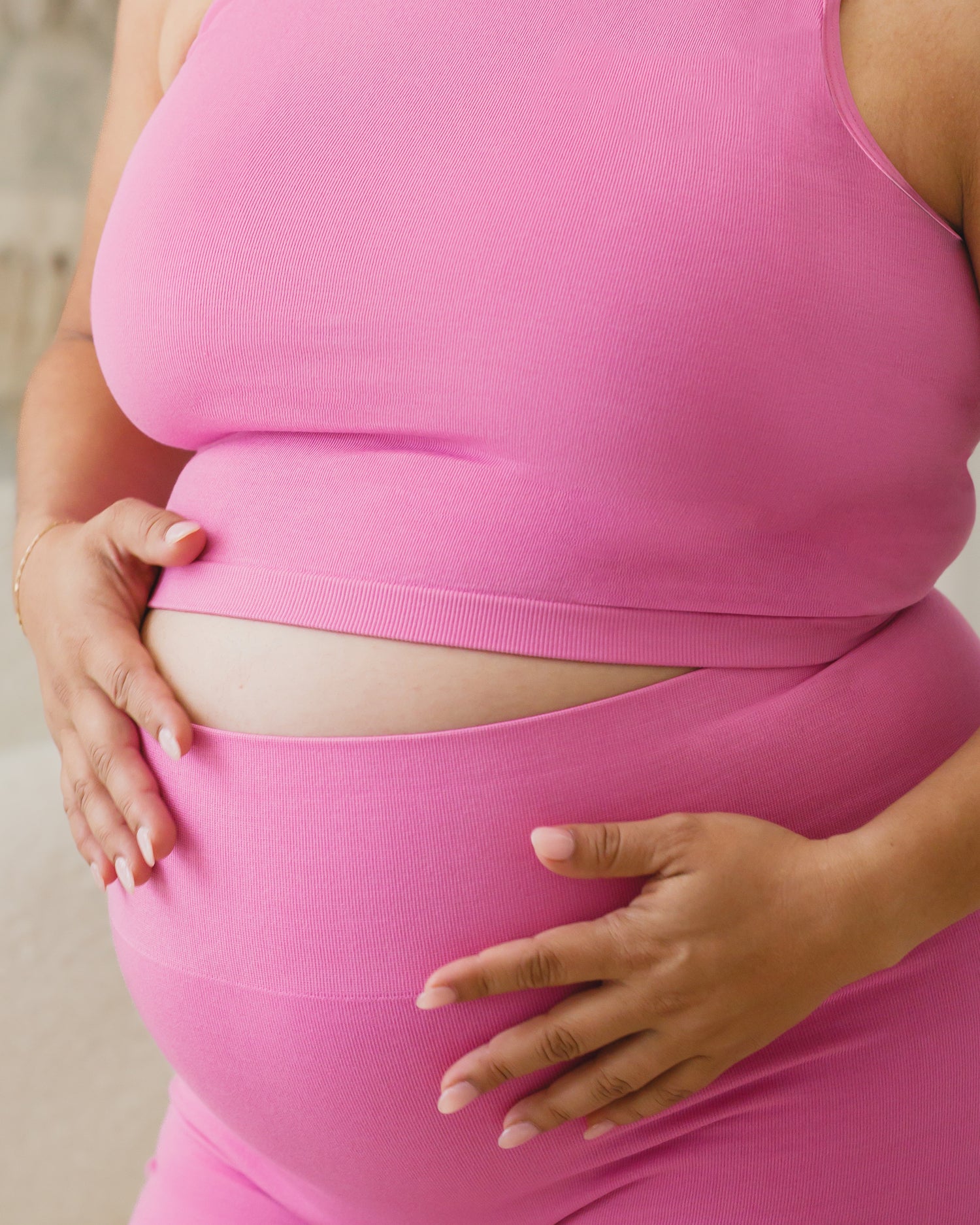 Cropped in view of pregnant model wearing the Sublime® Bamboo Maternity & Postpartum Bike Short in Soft Fuchsia, focusing on band and paired with matching Sublime® Bamboo Maternity & Nursing Longline Bra Top