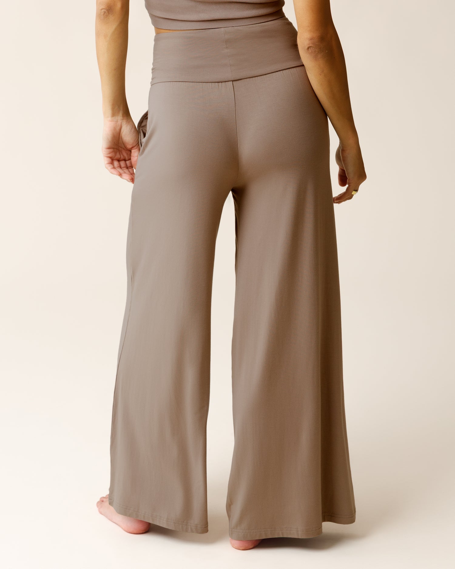 Woman wearing the Bamboo Wide Leg Maternity & Postpartum Lounge Pant in Taupe, showing back of pants