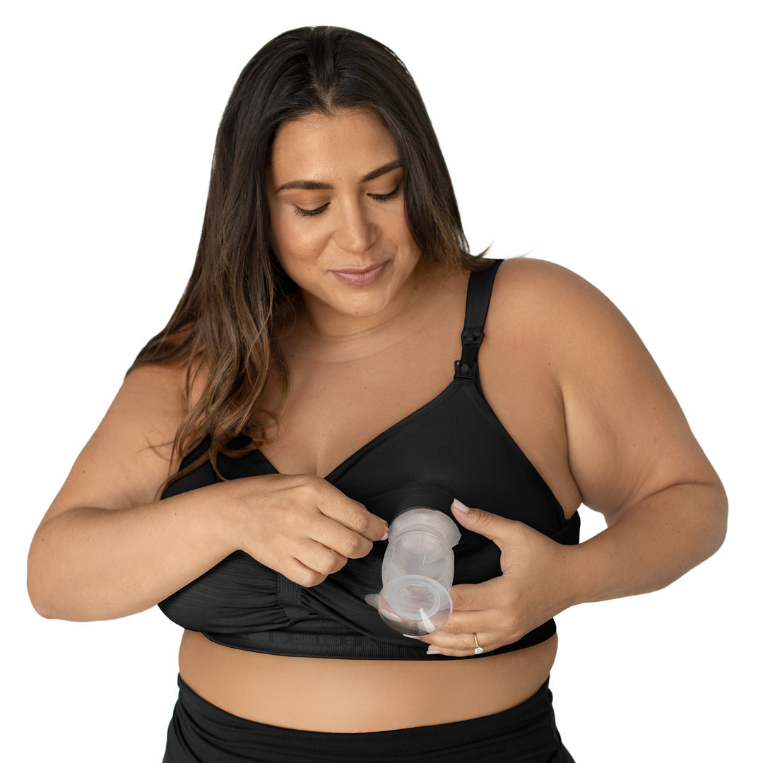 Model wearing the Sublime® Hands-Free Pumping & Nursing Bra - Super Busty in Black hooked up to a breast pump. 