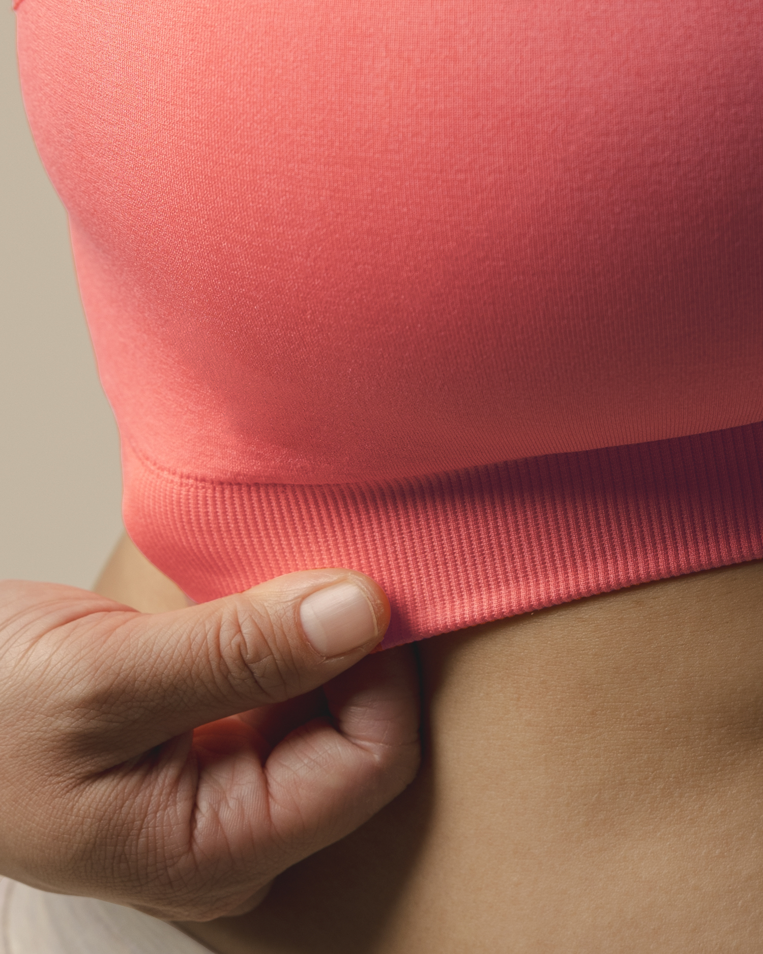 Close up of fabric and band detail on teh Tatum Seamless Maternity & Nursing Bralette in Coral Sunset
