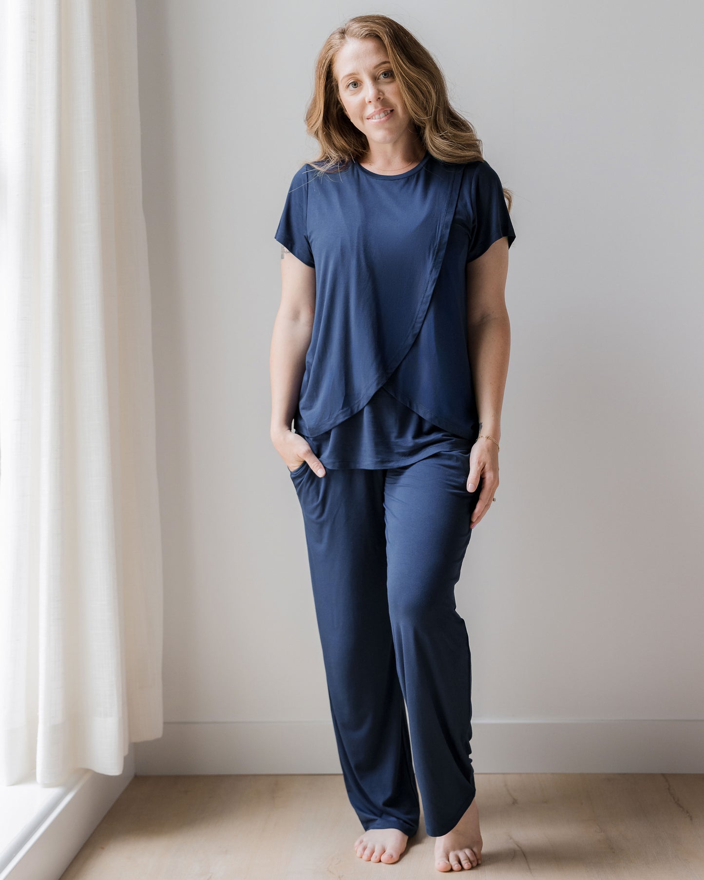 Model wearing a Short Sleeve Tulip Hem Maternity Pajama set - Top & Bottom in Navy Blue. @model_info: Ashley is wearing a Small.