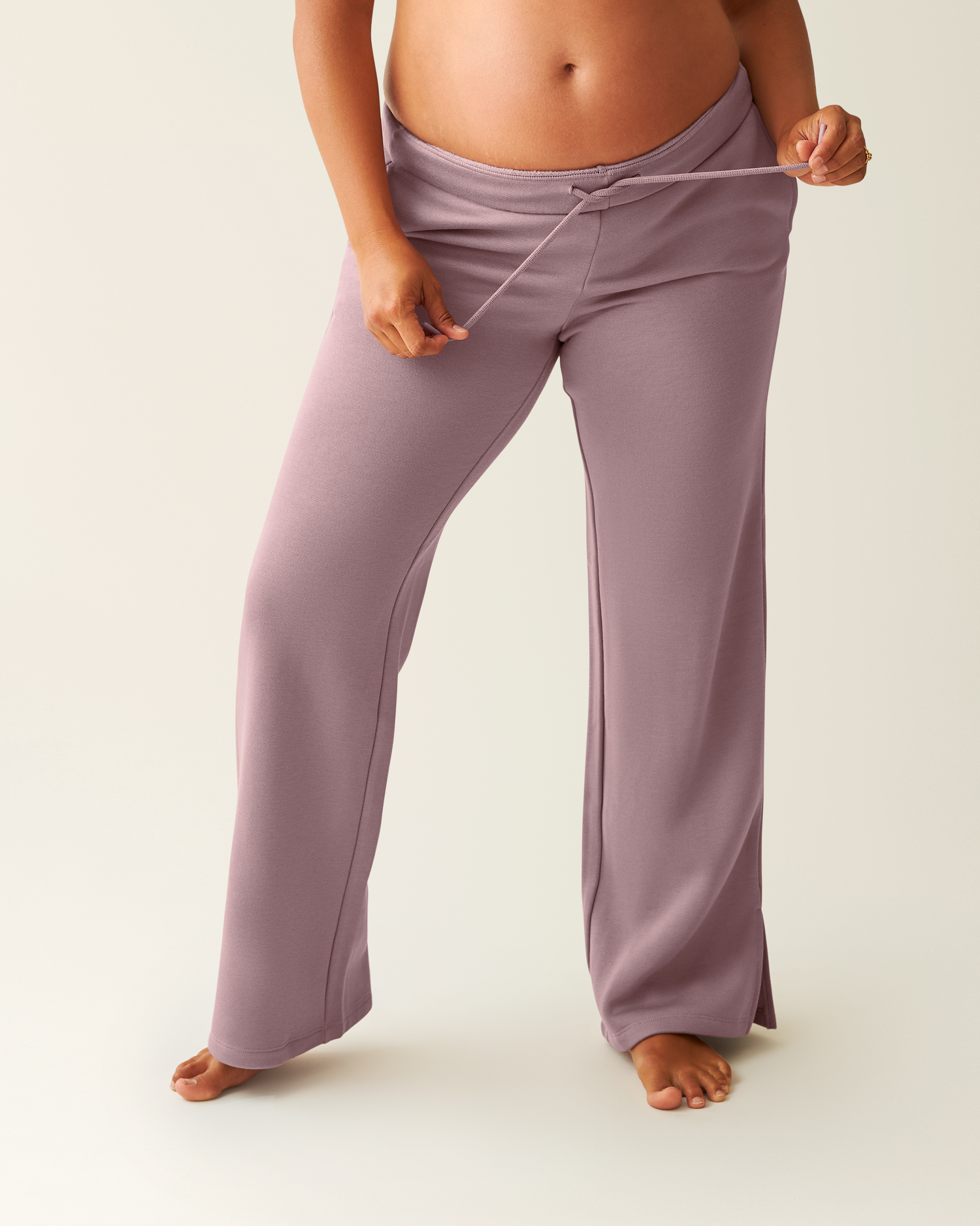 Woman wearing dusty mauve Cloud Fleece Sweatpant on a beige background@model_info:Zoe is 5'7" and wearing a Medium.