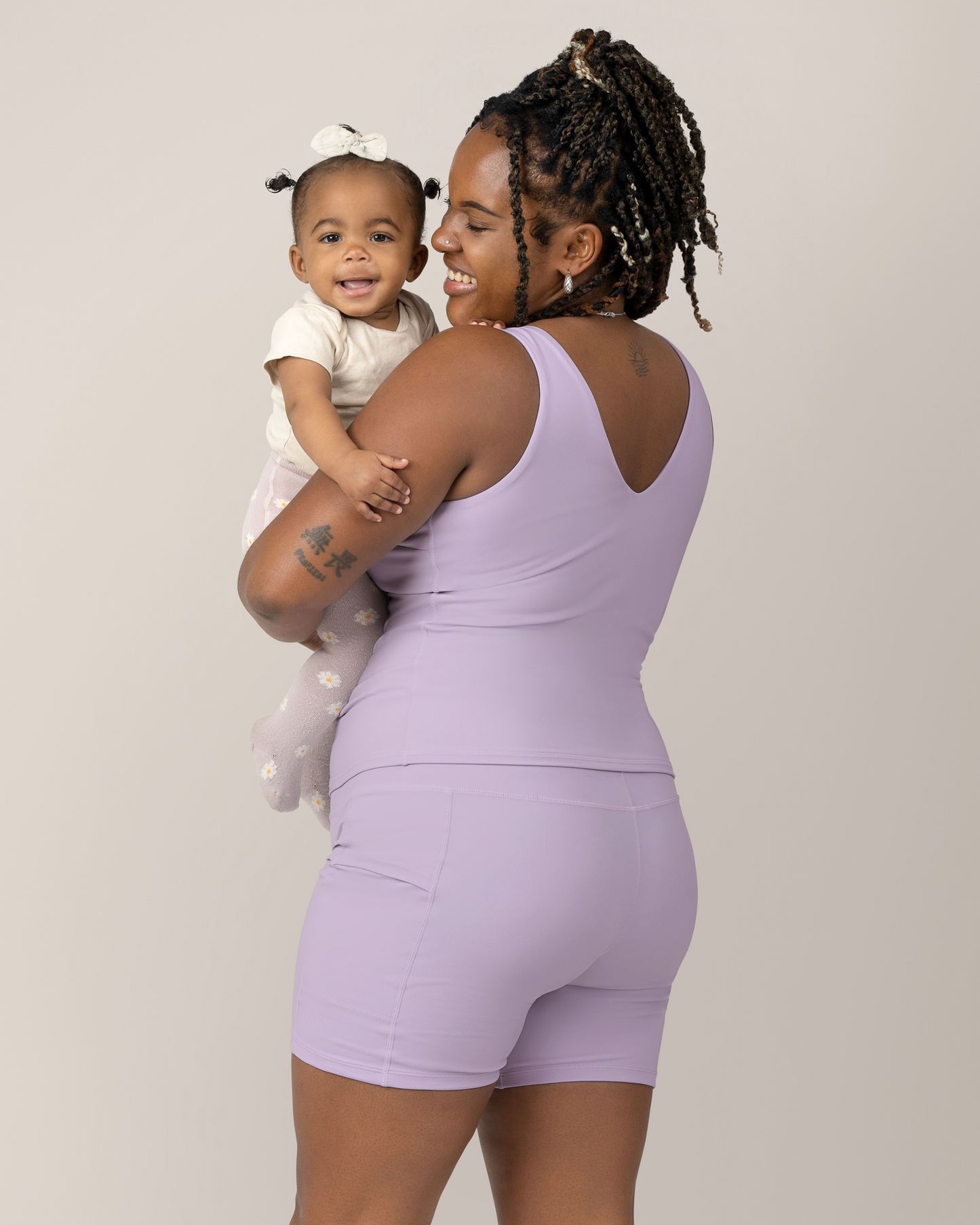 Side view of Model wearing the Stevie Active Postpartum Bike Short in Lavender Mist with the matching Wren Active V-Neck Nursing Tank Top