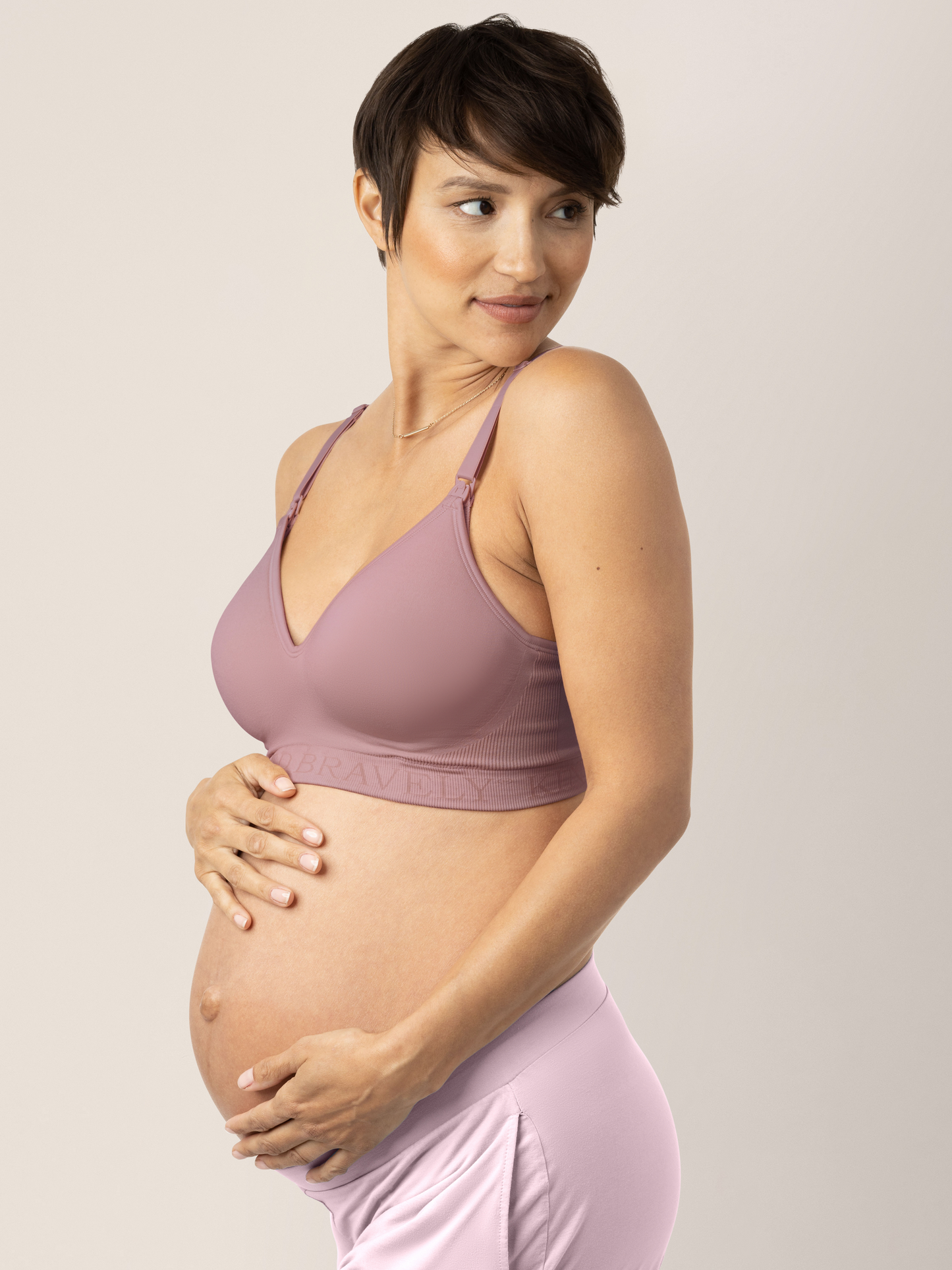 Side view of a pregnant model holding her baby bump while wearing the Signature Sublime® Contour Maternity & Nursing Bra in Twilight