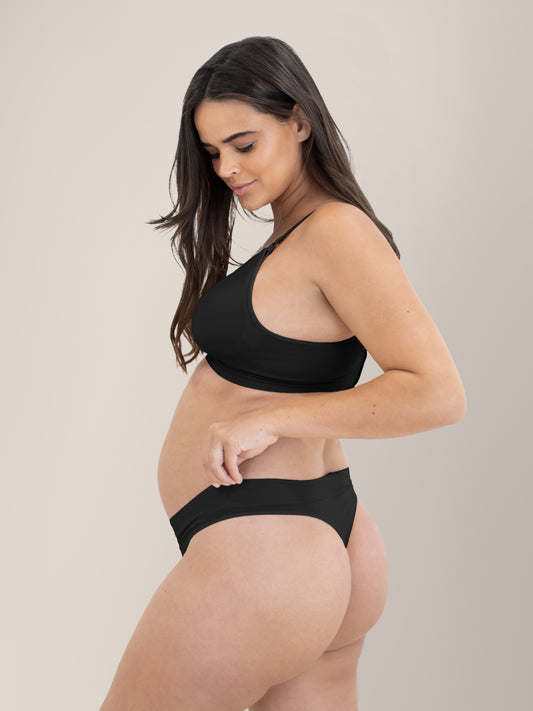 Model wearing the Bamboo Maternity & Postpartum Thong in Black with her hands on the waistband. @model_info:Brooklyn is wearing a Small.