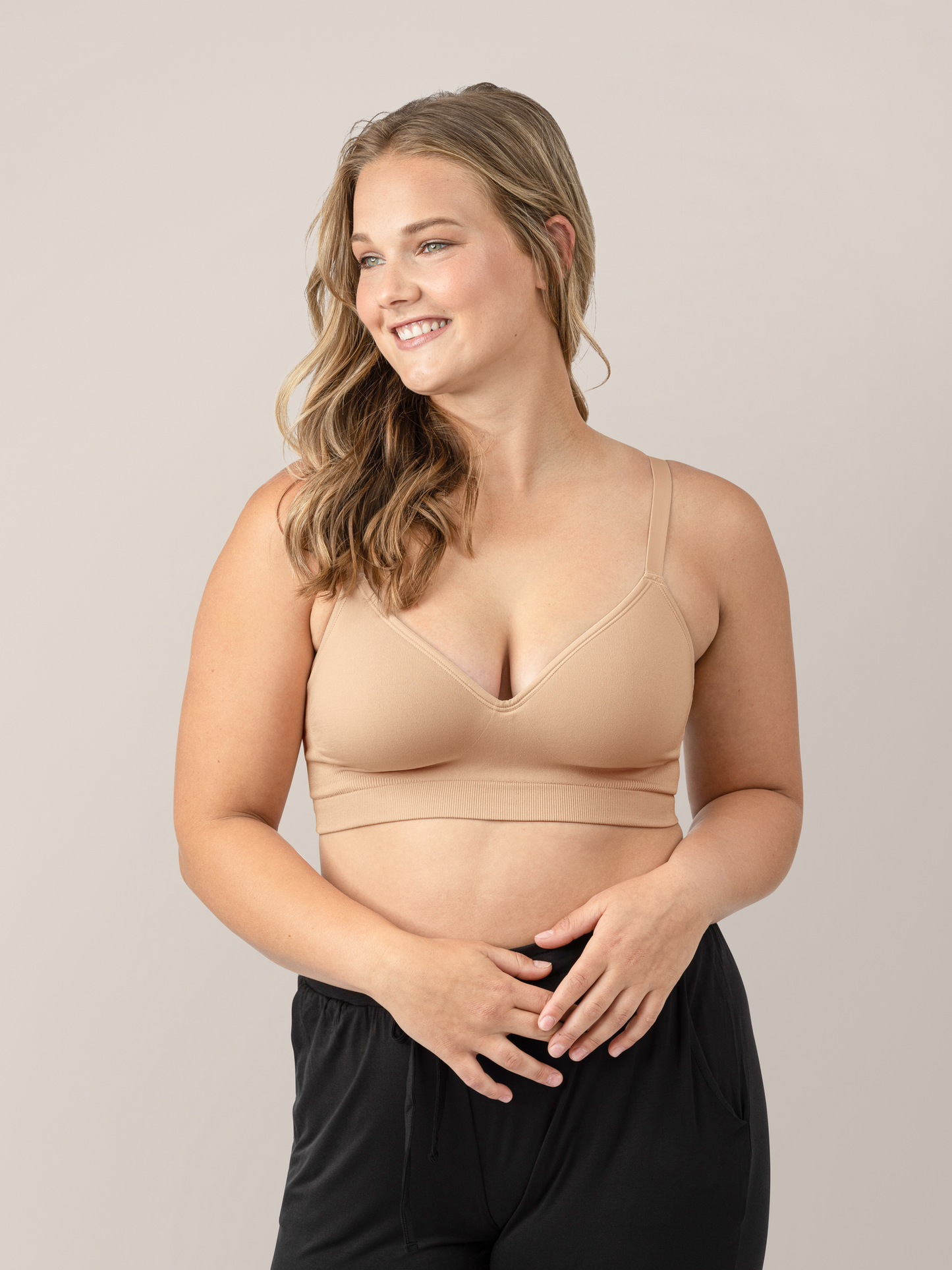 Model wearing the Everly Wireless Contour Bra  in Beige with her hands on her waistband @model_info:Myla is wearing a Medium.