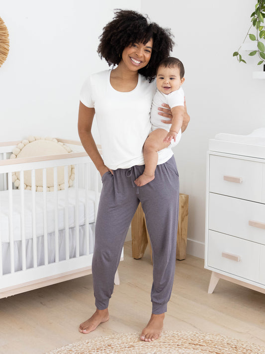 Model holding her baby while wearing the Everyday Lounge Jogger in Heathered Granite @model_info:Tess is 5'5" and wearing a Small Regular.