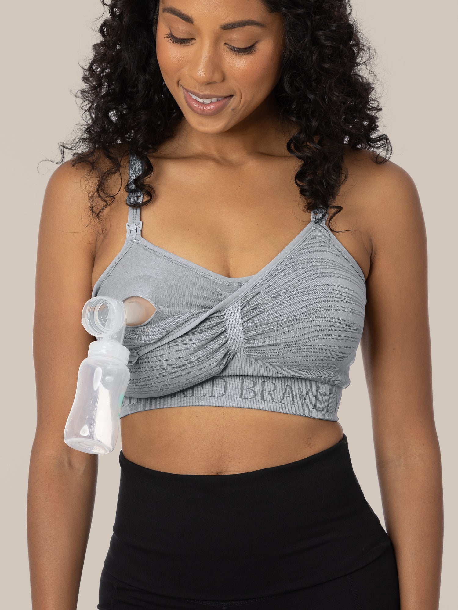 Model wearing the Sublime® Hands-Free Pumping & Nursing Bra in Grey, showing the clip down pumping and nursing access.