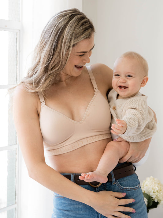 Model with her baby on her hip wearing the Signature Sublime® Contour Maternity & Nursing Bra in Beige @model_info:Taylor is wearing a Medium Regular.